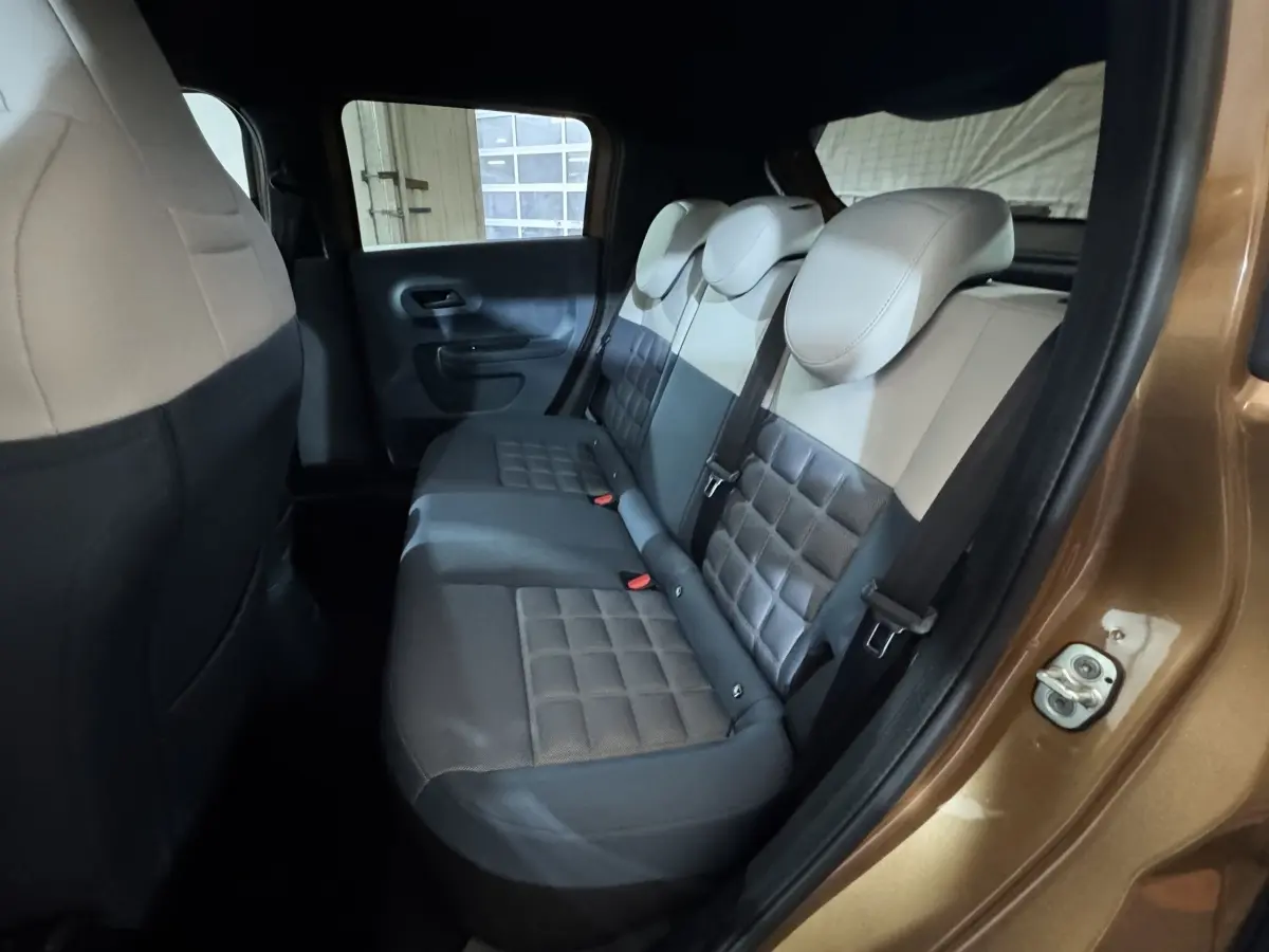 Vue intérieure côté droit sur la banquette arrière bi-ton beige et gris du Fiat Grande Panda marron 2025.