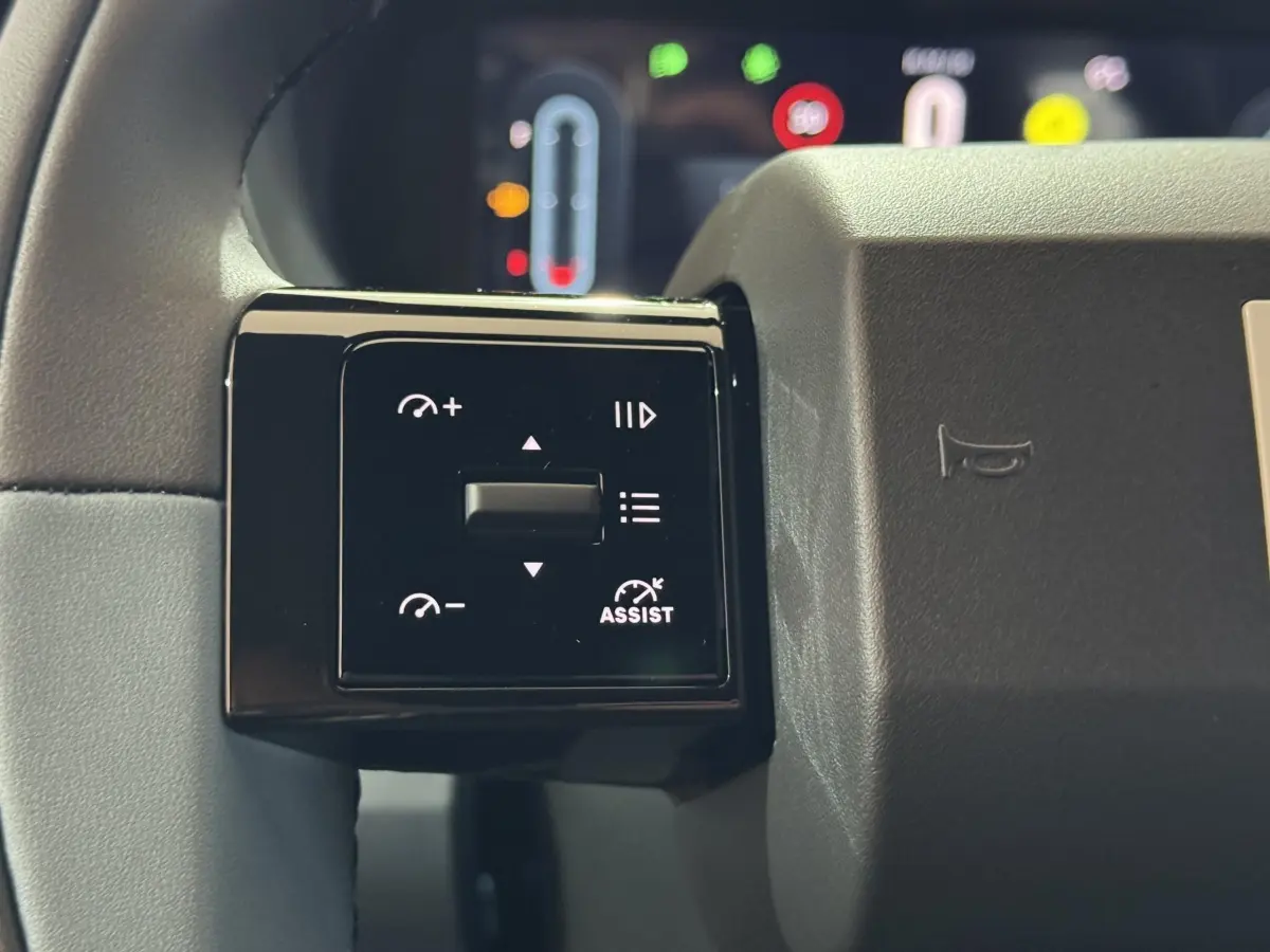 Gros plan sur les commandes multifonctions noires à gauche du volant de la Fiat Grande Panda marron 2025.