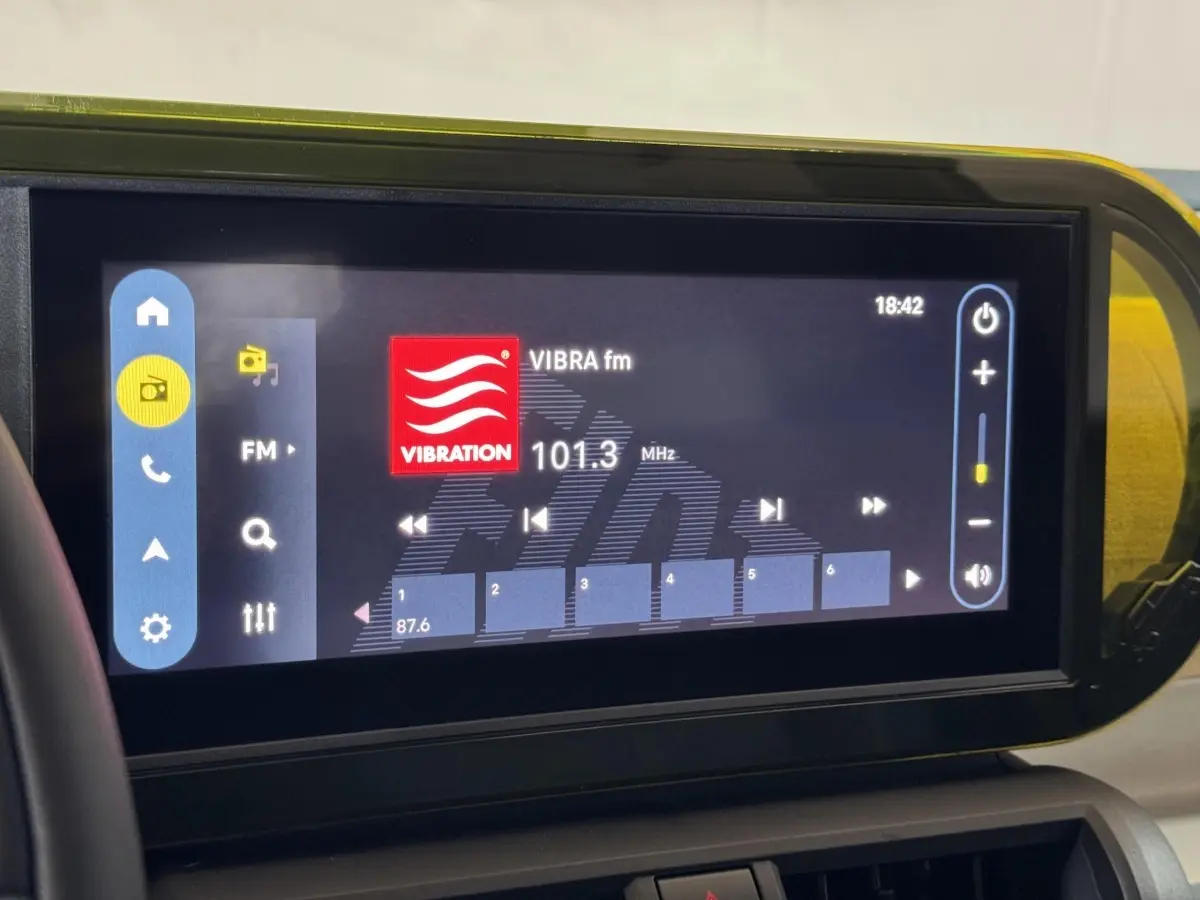 Écran tactile central de la Fiat Grande Panda marron affichant la radio FM à 101,3 MHz en intérieur.