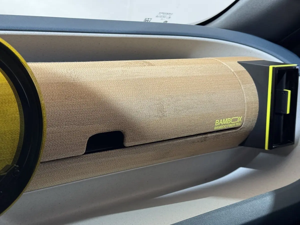 Détail intérieur du tableau de bord beige avec inscription "BAMBOX" et sortie d'air noire et jaune sur FIAT Grande Panda.