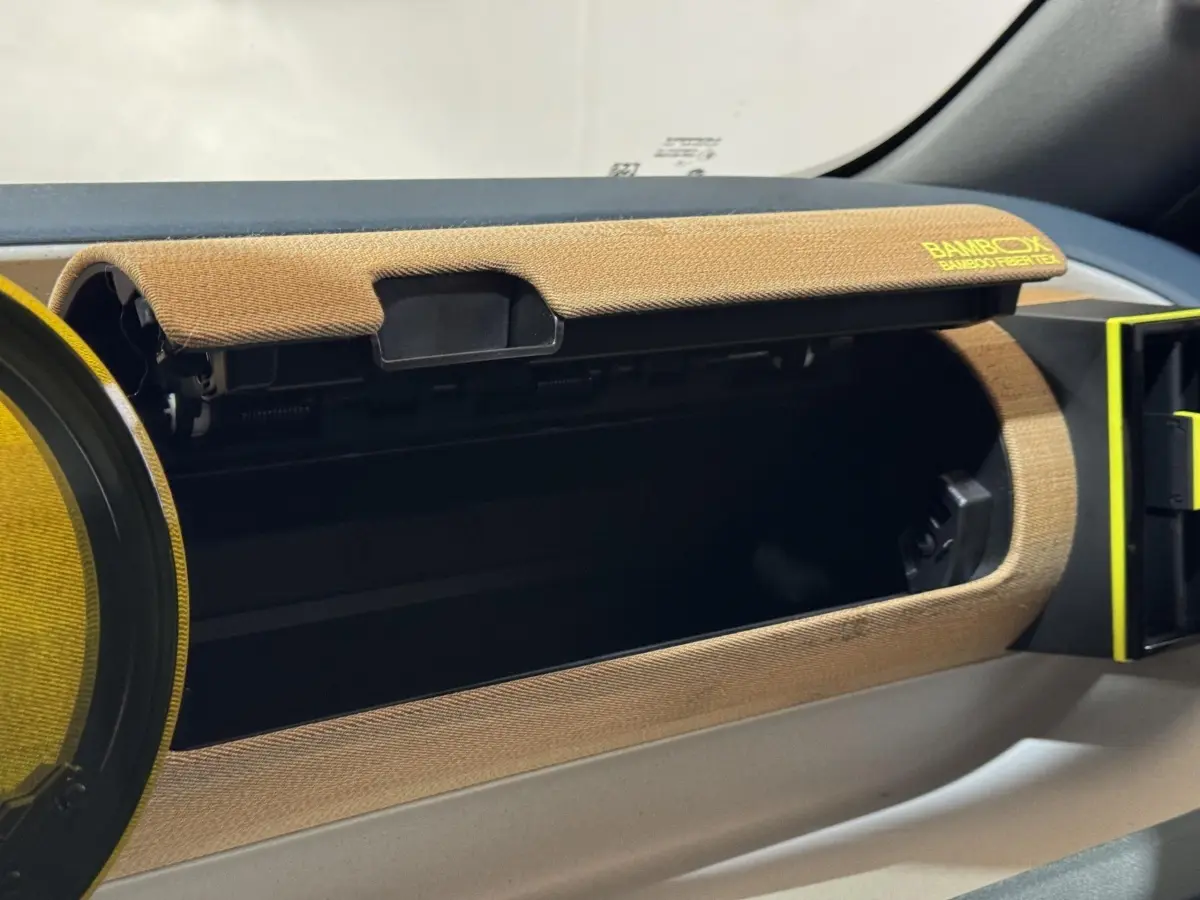 Intérieur de la FIAT Grande Panda 2025, détail de la boîte à gants ouverte avec habillage marron texturé Bambox.