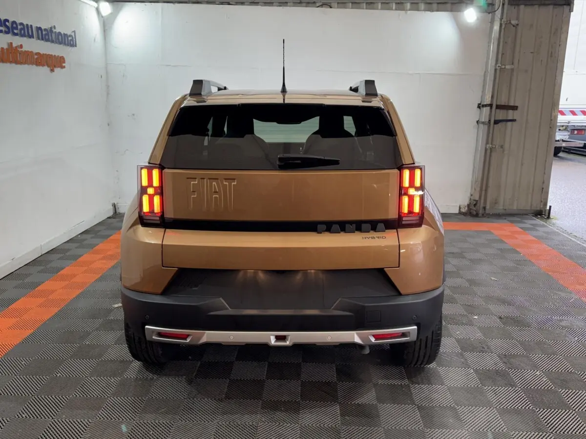 Vue arrière de la FIAT Grande Panda marron 2025 avec feux LED allumés et barres de toit visibles.