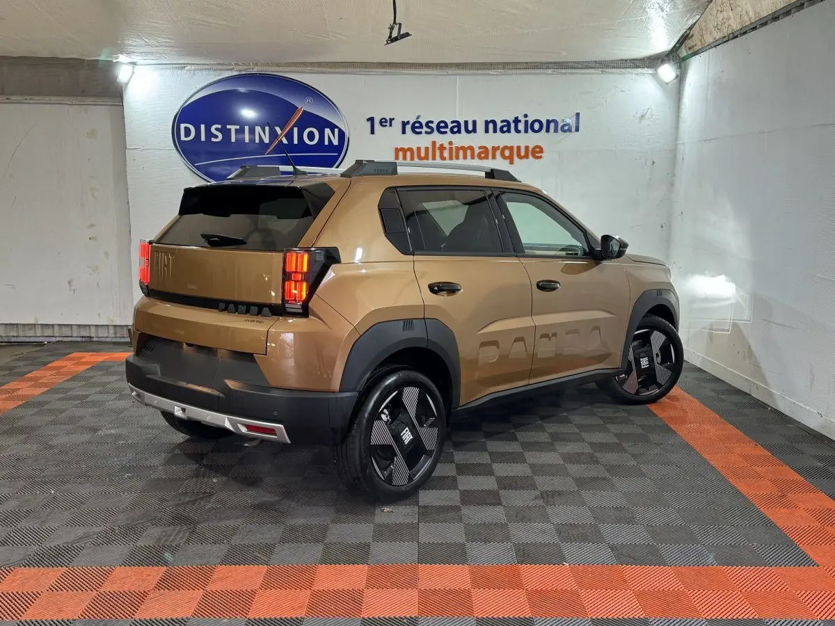 Vue 3/4 arrière droite d'une FIAT Grande Panda marron avec jantes noires et détails noirs contrastants dans un garage.