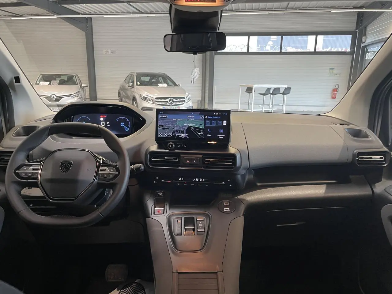 Vue intérieure avant du Peugeot Rifter 2026, tableau de bord avec écran tactile central et volant multifonction noir.