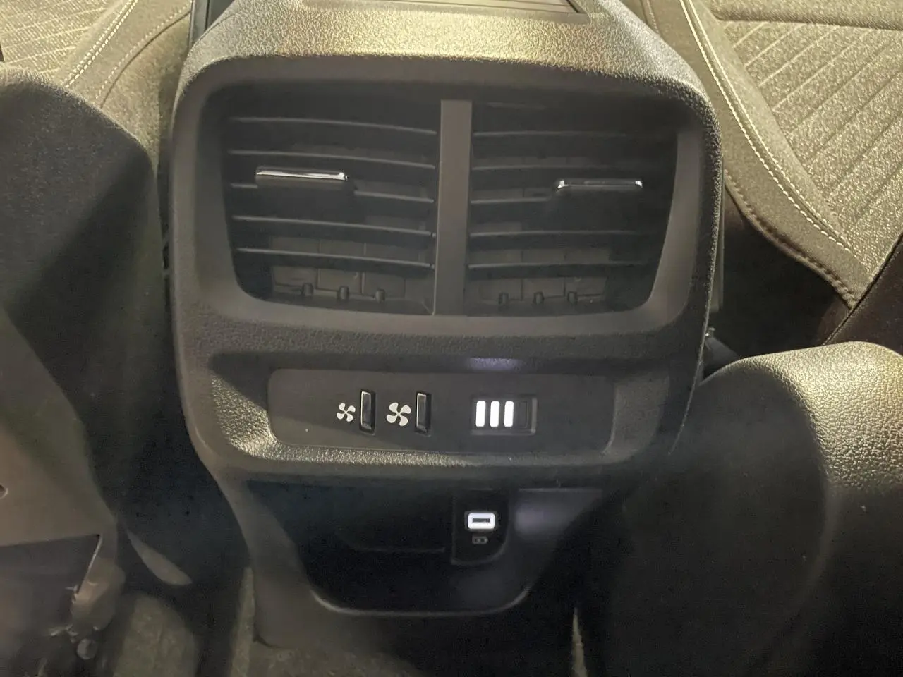 Vue rapprochée des aérateurs arrière et des ports USB Type-C du Peugeot Rifter gris Artense, version 2026.