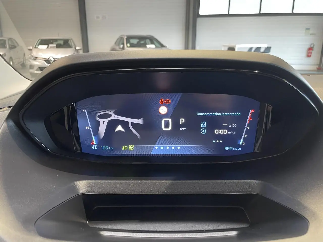 Affichage numérique 10 pouces du combiné de bord du Peugeot Rifter gris Artense, montrant la navigation et la consommation instantanée.