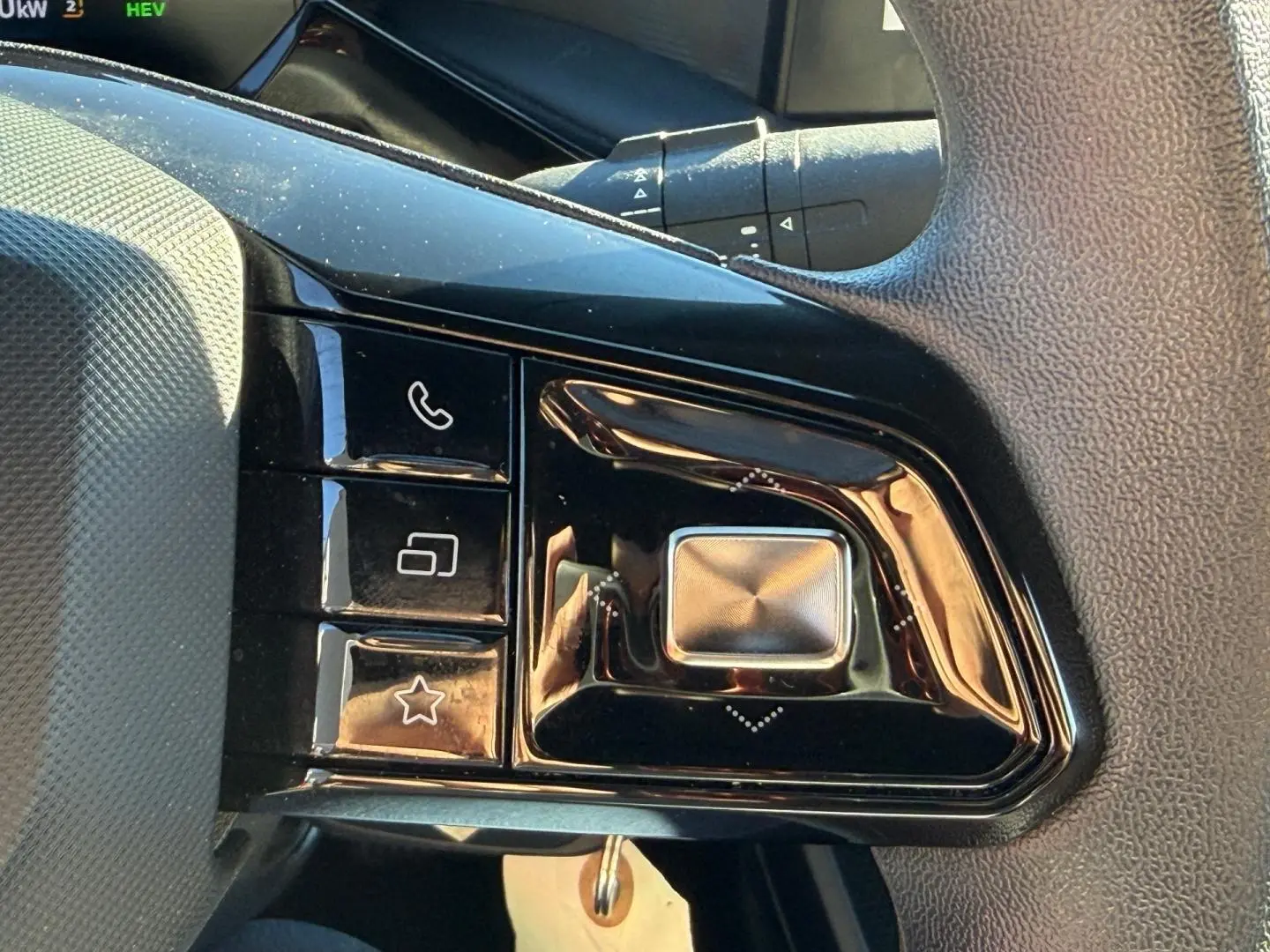 Gros plan sur les commandes multifonctions noires du volant côté gauche du MG3 Pebble Black 2024.