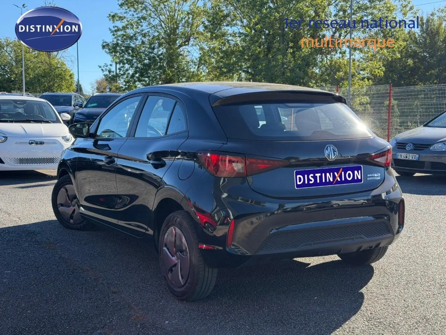 Vue 3/4 arrière droite d'une MG3 1.5 Hybrid+ 2024 en Pebble Black métallisé sur parking extérieur.