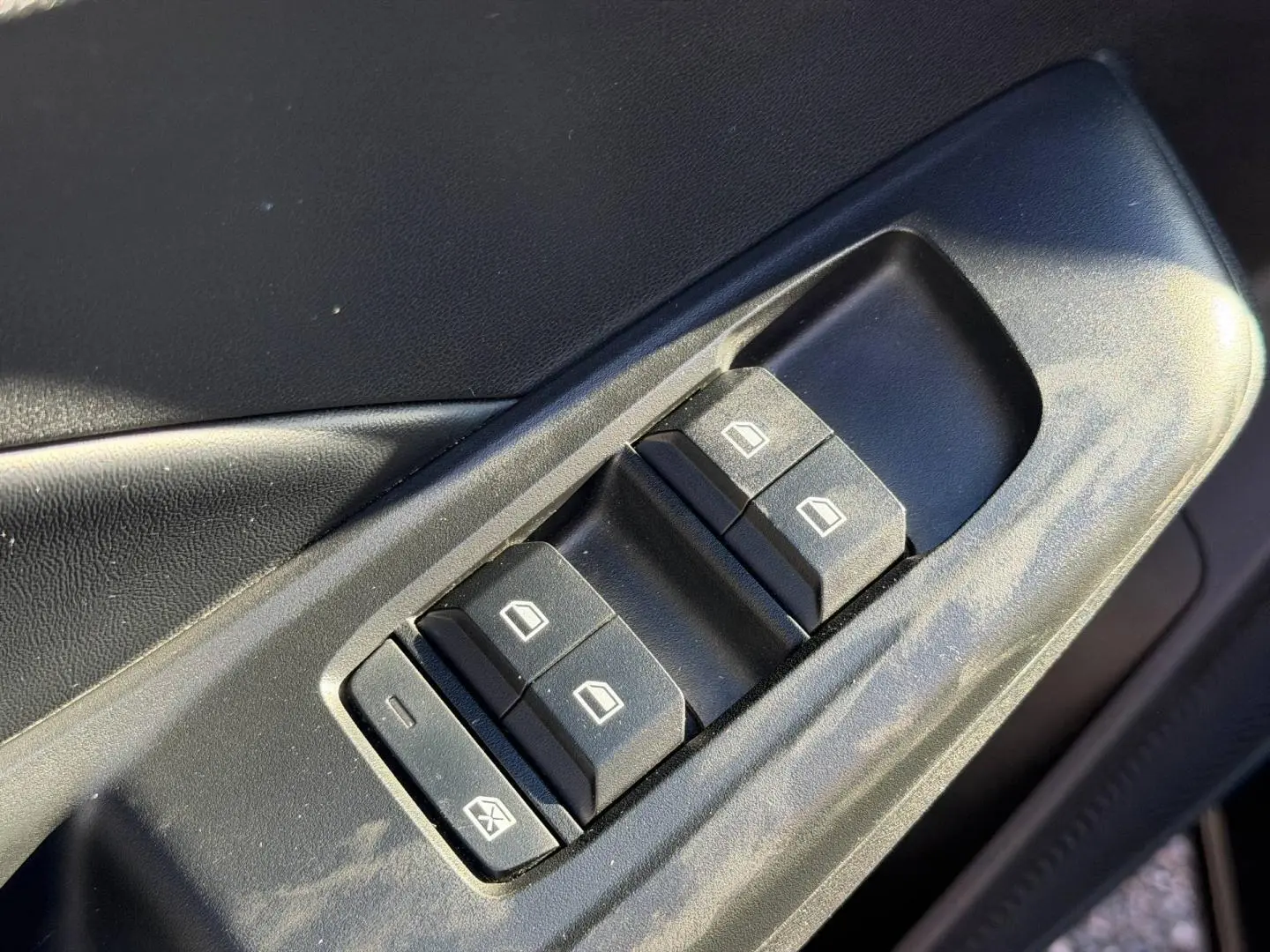 Gros plan sur les commandes des vitres électriques côté conducteur de la MG3 1.5 Hybrid+ Pebble Black 2024.