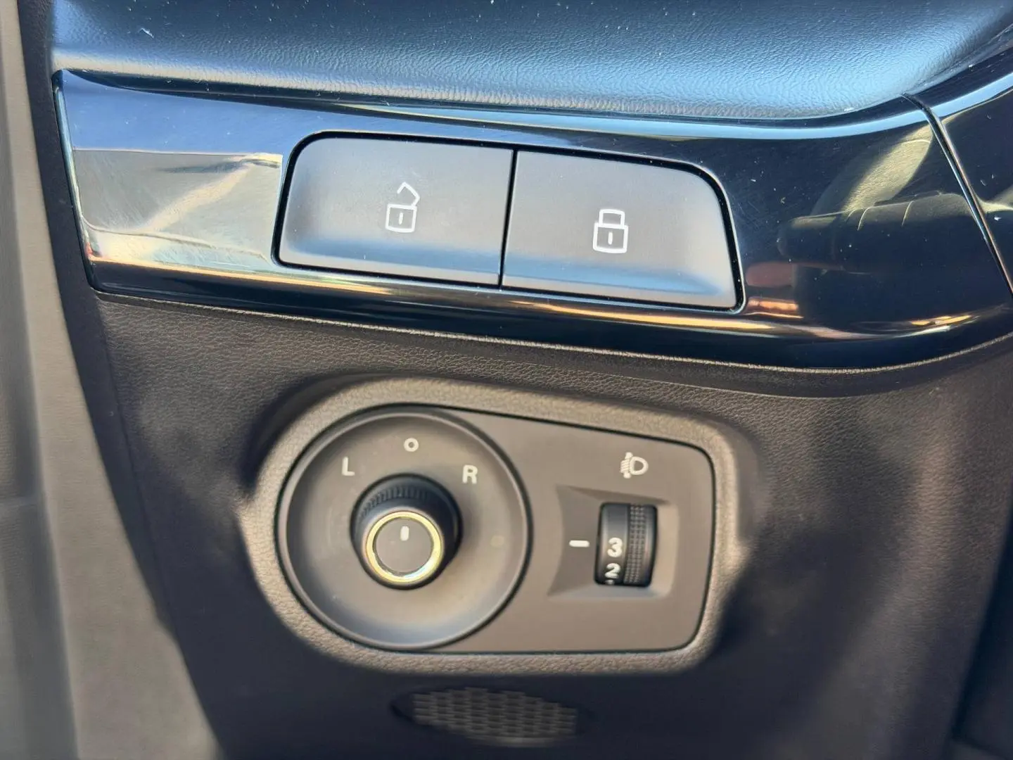 Gros plan sur les commandes de réglage des rétroviseurs et verrouillage, intérieur noir du MG3 2024 Pebble Black.