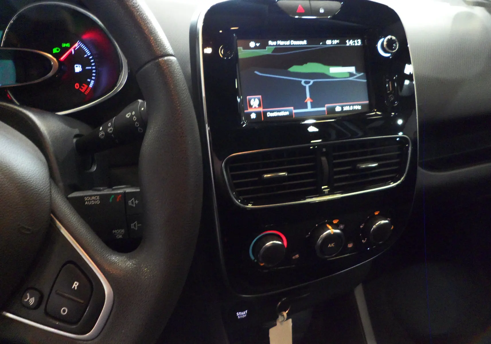 Vue intérieure du tableau de bord de la Renault Clio IV Société blanc glacier, avec écran tactile GPS et commandes de climatisation.