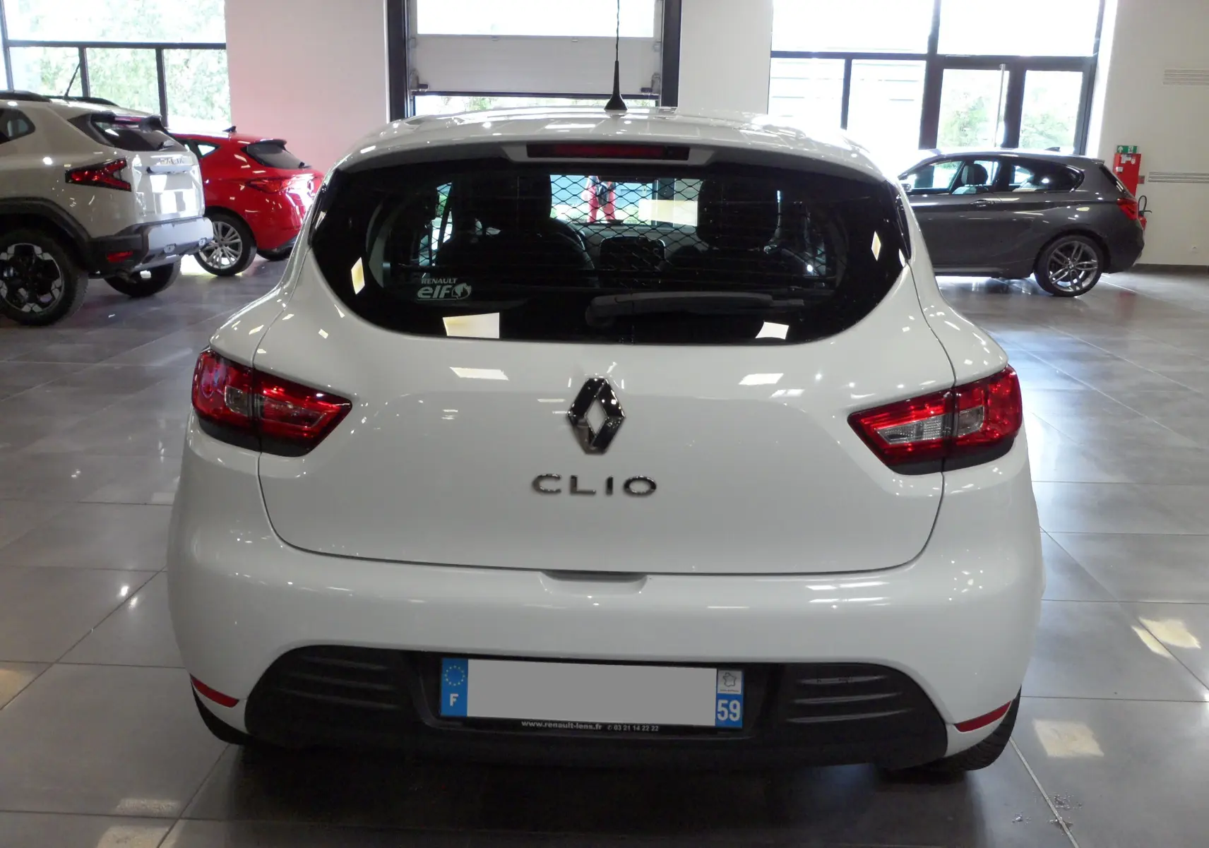 Vue arrière d'une Renault Clio IV Société blanche Glacier avec grille de séparation visible à l'intérieur.