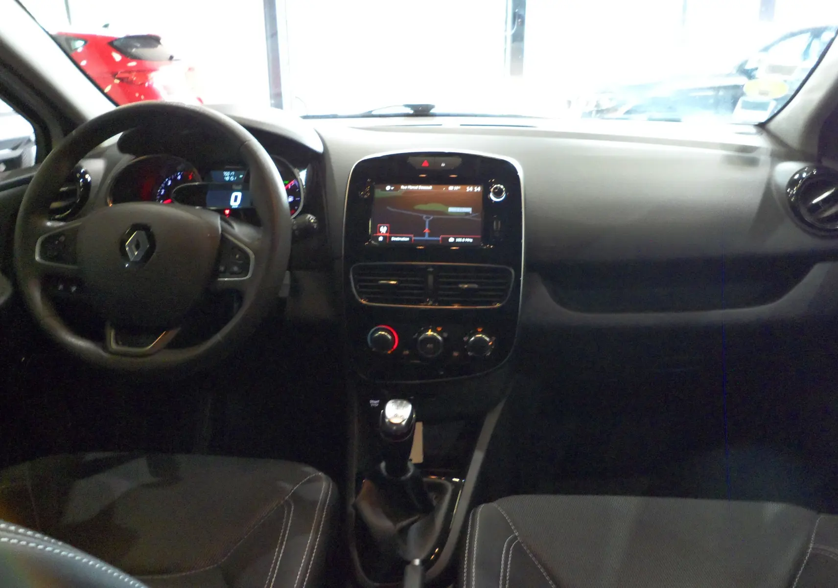 Intérieur de la Renault Clio IV Société 2019, vue frontale du tableau de bord avec écran tactile et levier de vitesse manuel.