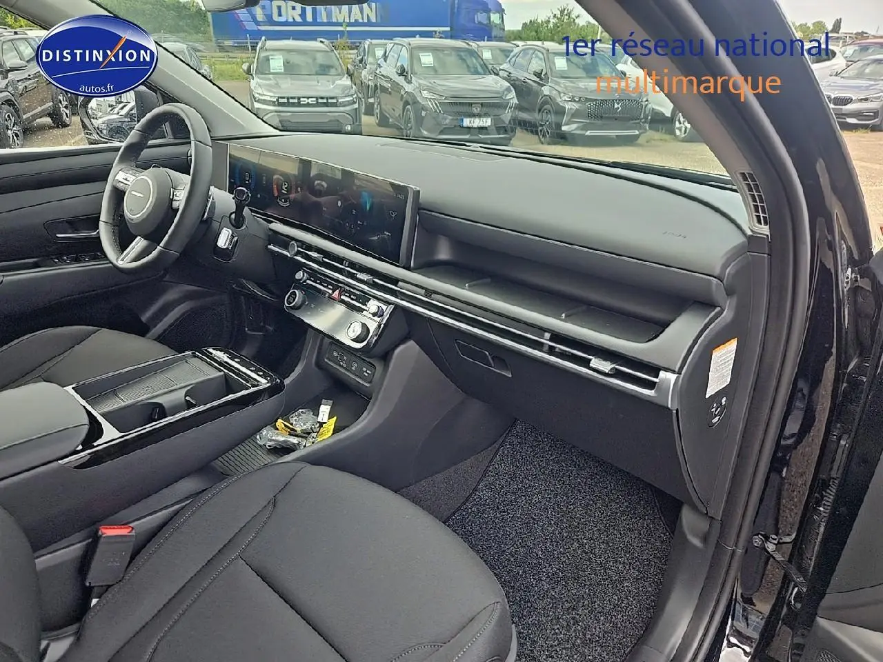 Intérieur noir du Hyundai Tucson 2025 vu côté passager, avec tableau de bord moderne et écran tactile large.