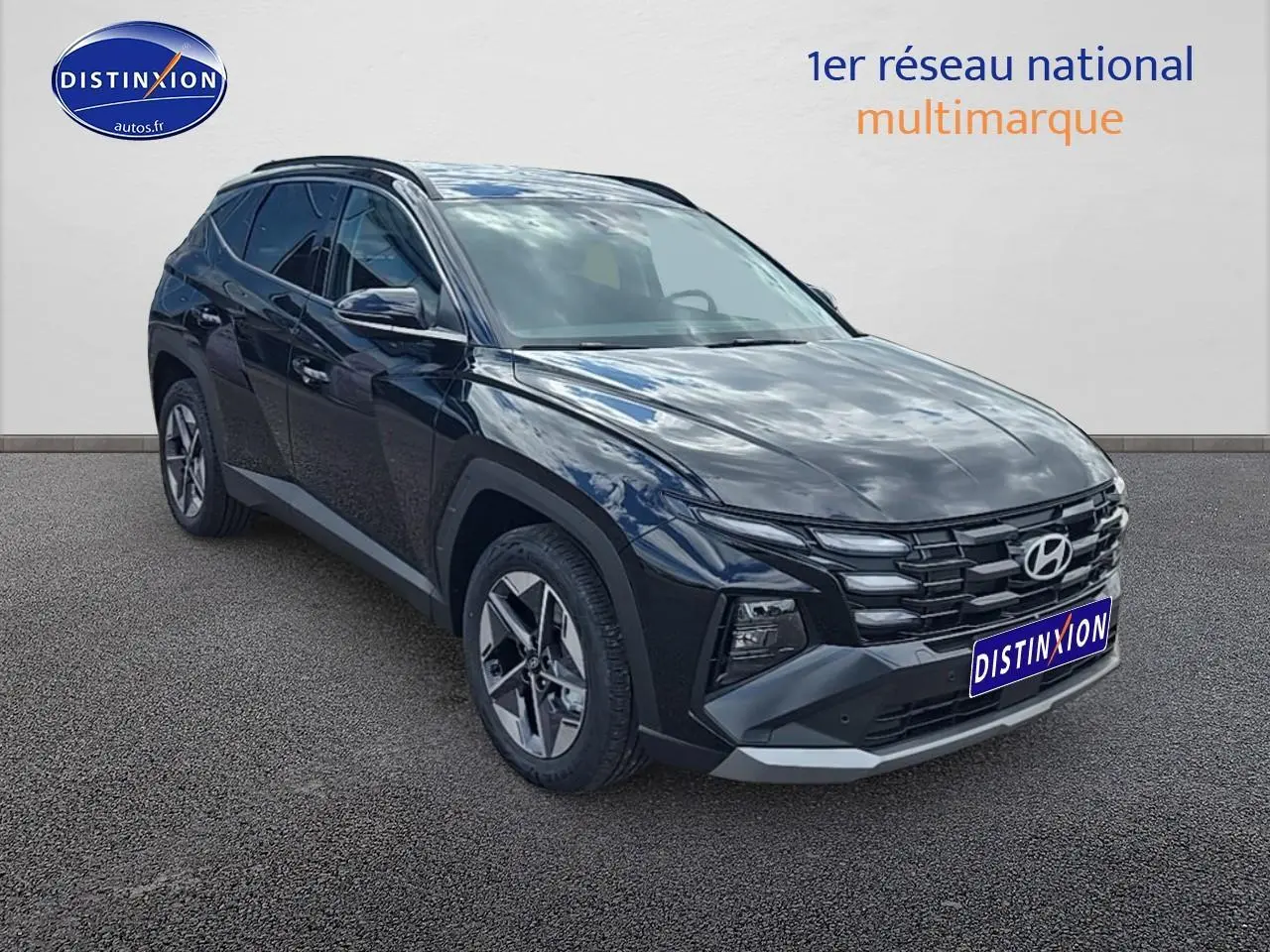 Vue 3/4 avant du Hyundai Tucson 2025 noir abysse avec jantes alliage et barres de toit visibles.