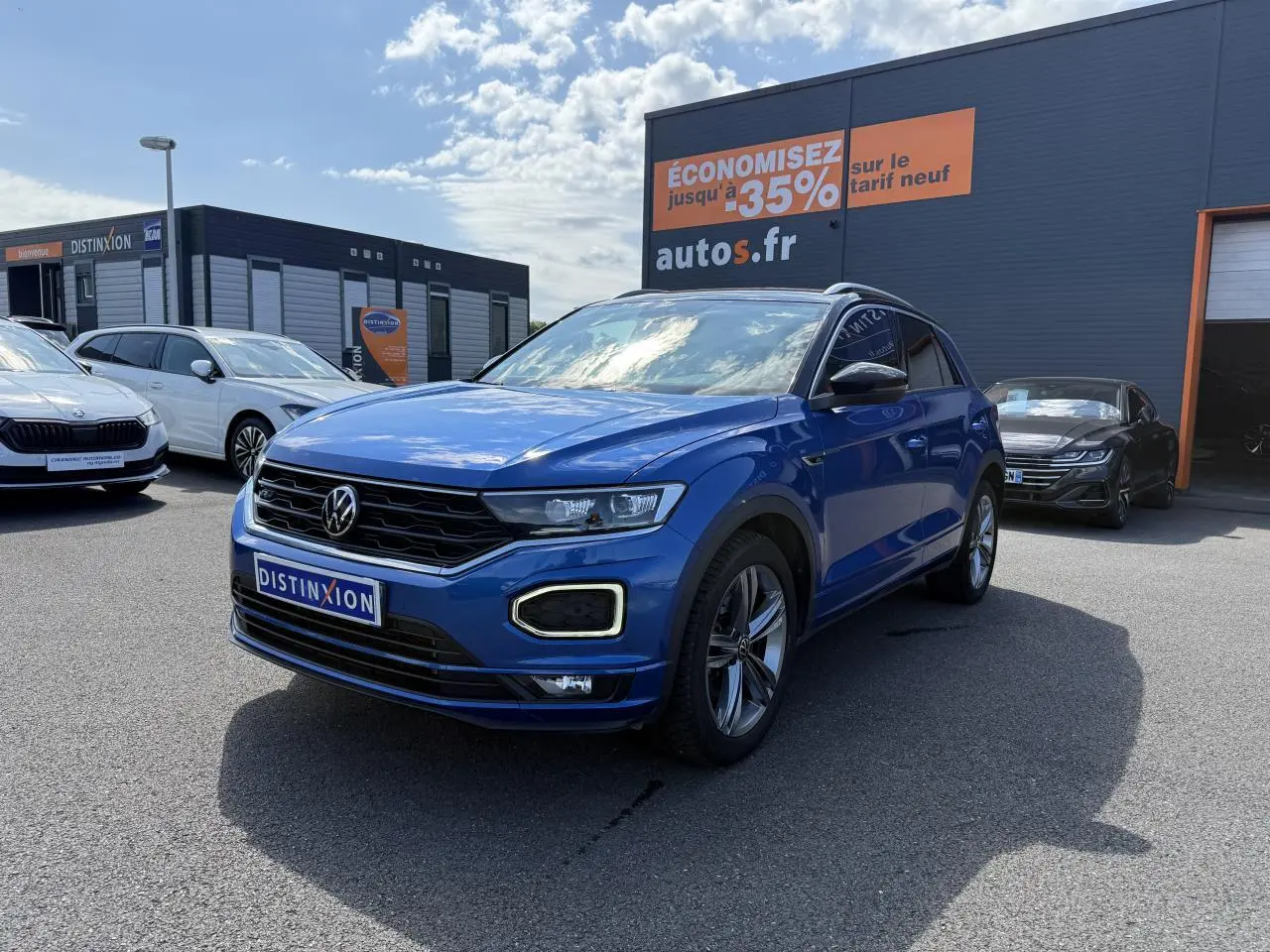 Volkswagen T-Roc bleu Ravenna métallisé en 3/4 avant droit avec jantes alliage et calandre noire distinctive.