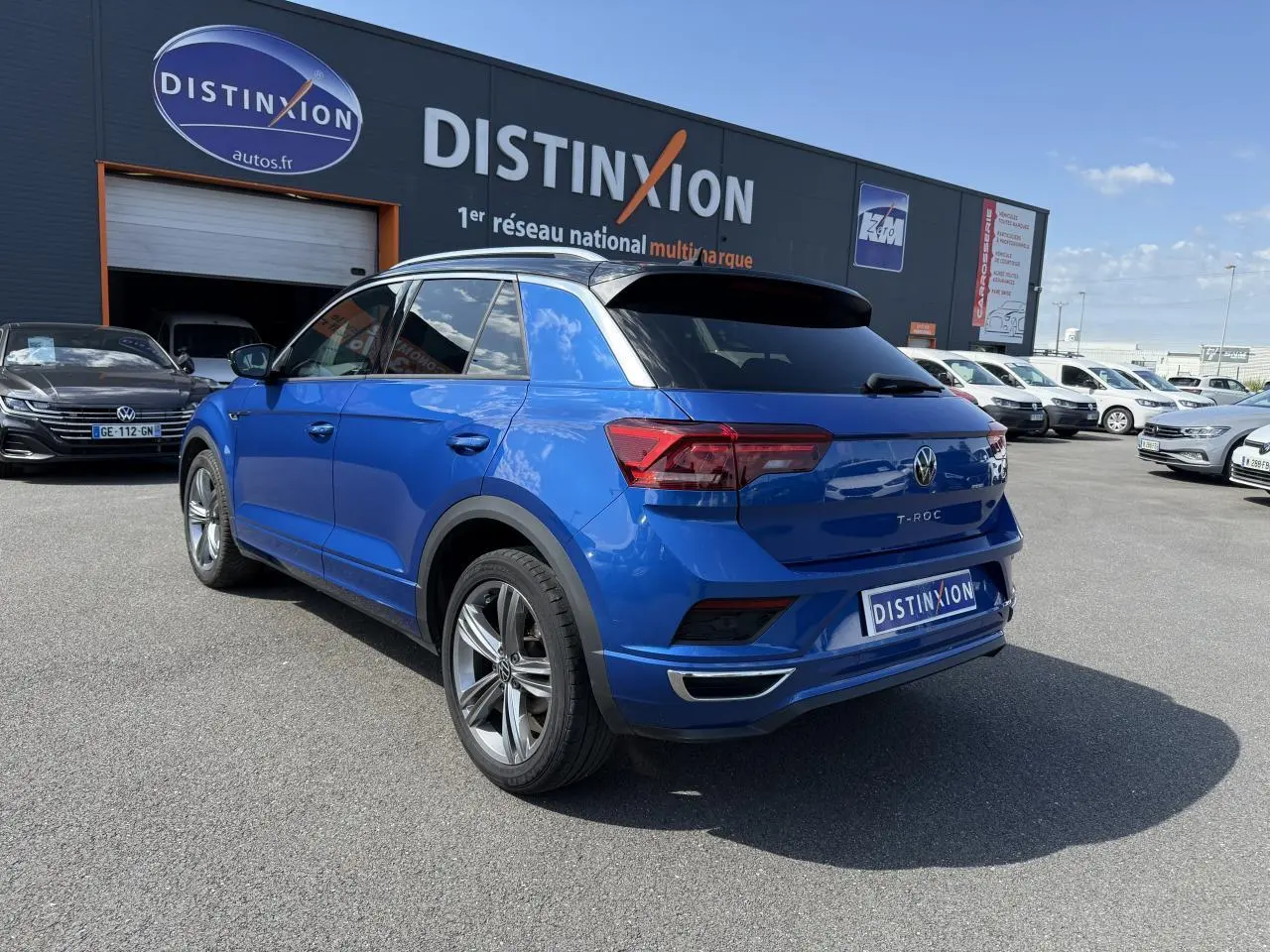 Volkswagen T-Roc bleu Ravenna métallisé vu de l'arrière côté gauche, avec jantes alliage 18 pouces et toit noir.