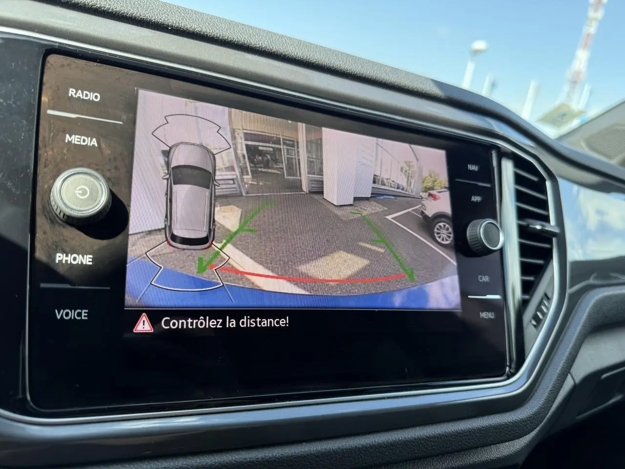 Écran de caméra de recul du Volkswagen T-Roc bleu Ravenna, vue arrière avec guidage de trajectoire verte et rouge.