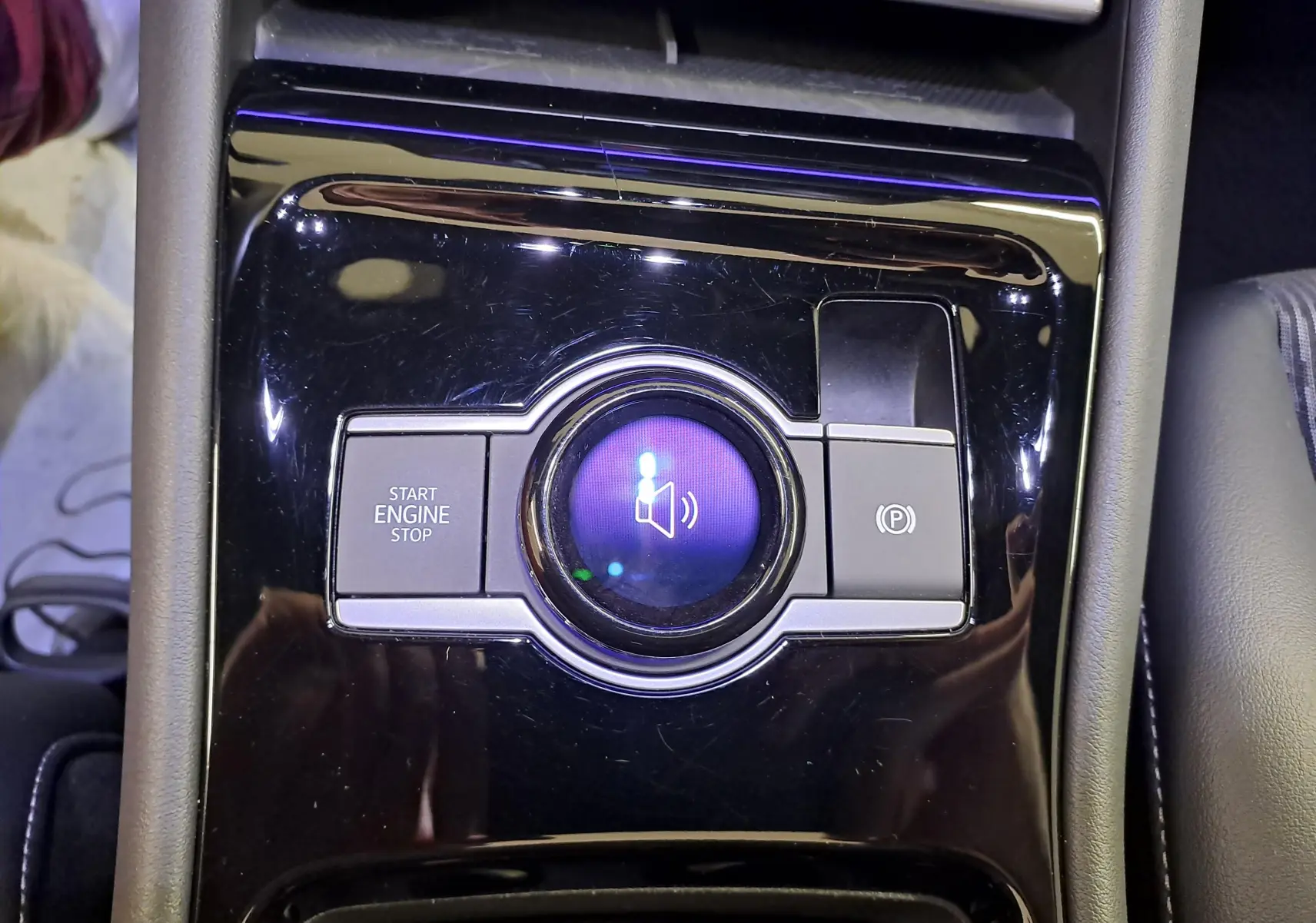 Gros plan sur la console centrale noire brillante du Volkswagen Tiguan 2025 avec bouton start/stop et frein à main électronique.