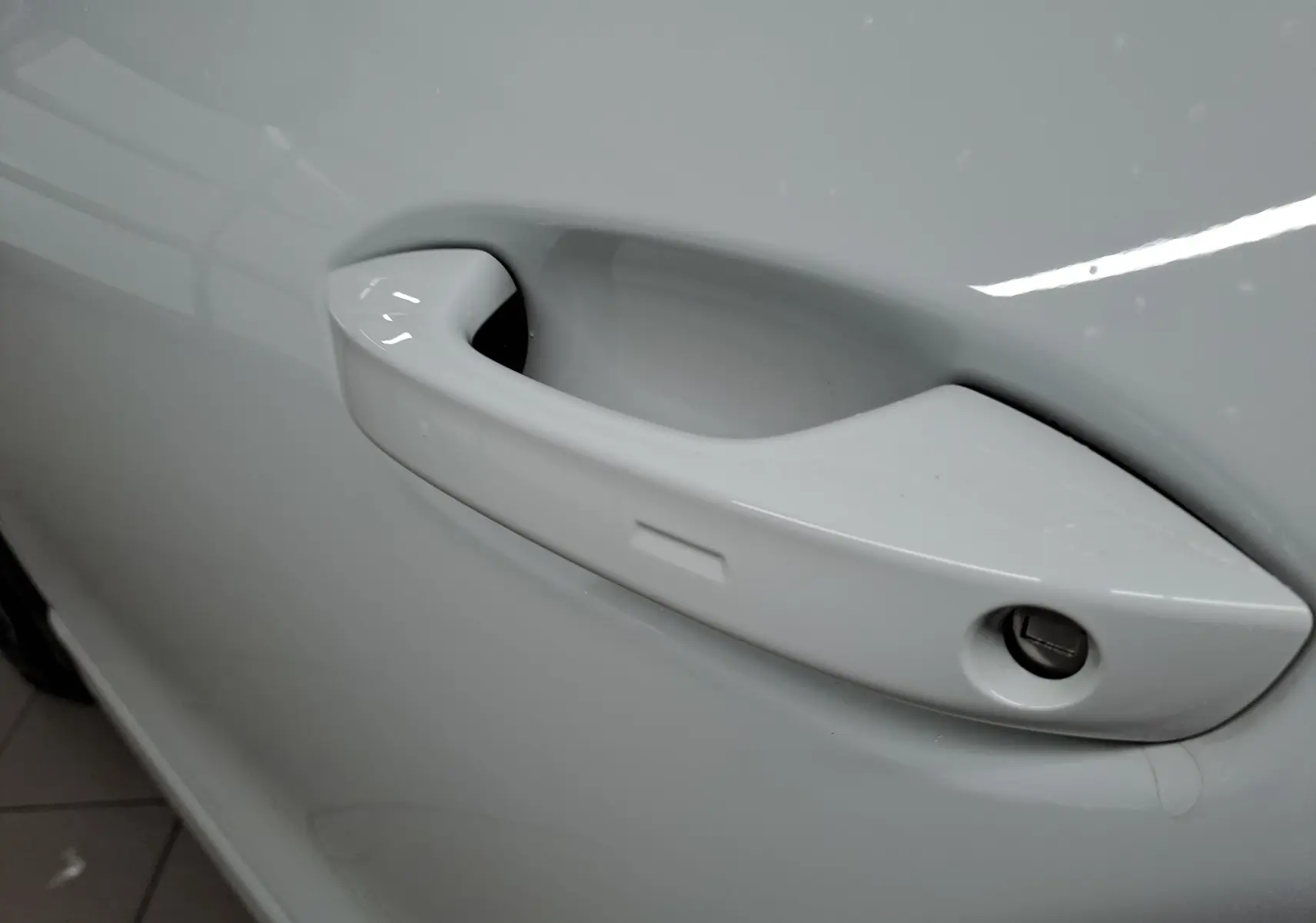 Poignée de porte blanche vue de près sur le côté gauche d'un Volkswagen Tiguan 2025 finition R-Line.