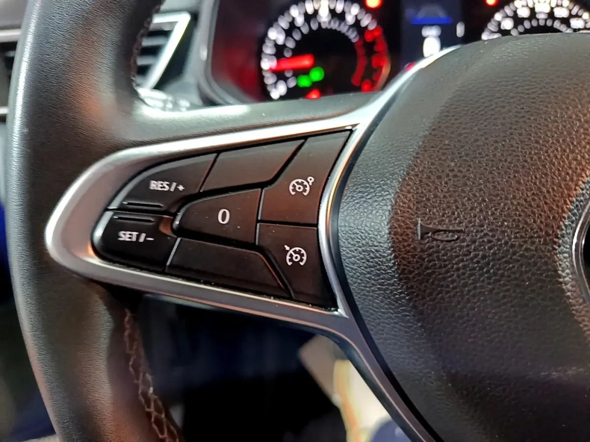 Gros plan sur le volant cuir synthétique noir de la Renault Clio Business 2022, avec commandes multifonctions visibles.