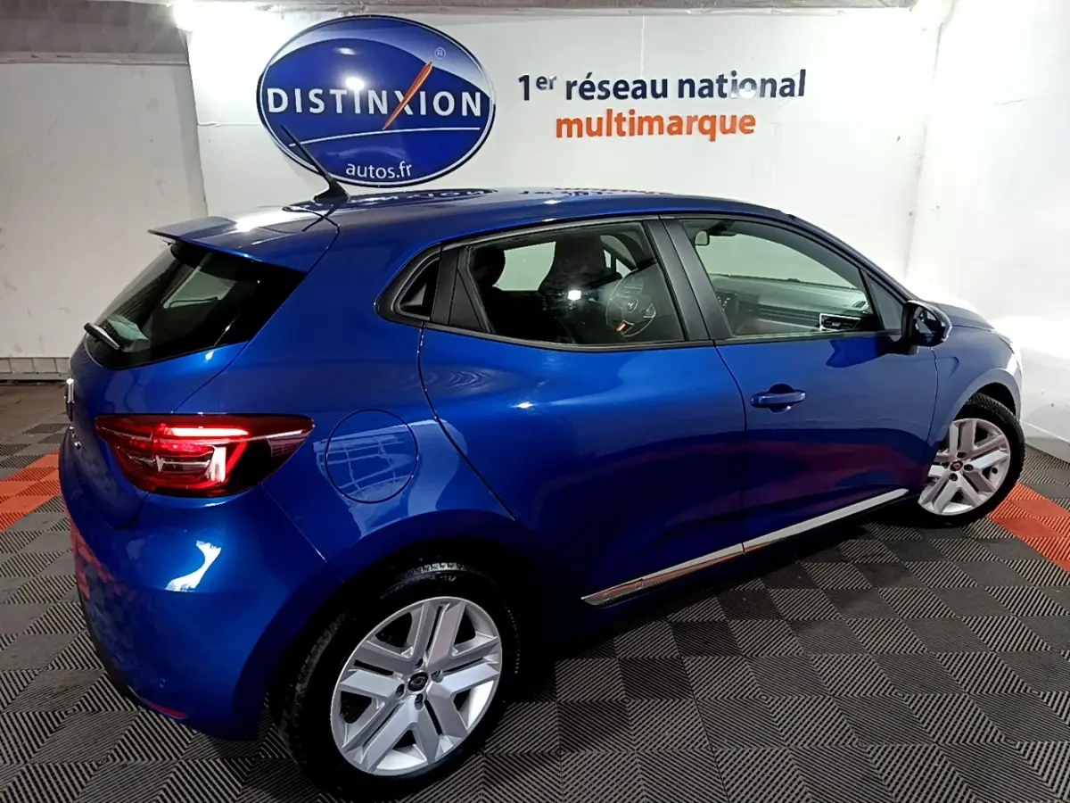 Vue 3/4 arrière droite d'une Renault Clio Business bleu, avec jantes alliage et feux arrière LED allumés.