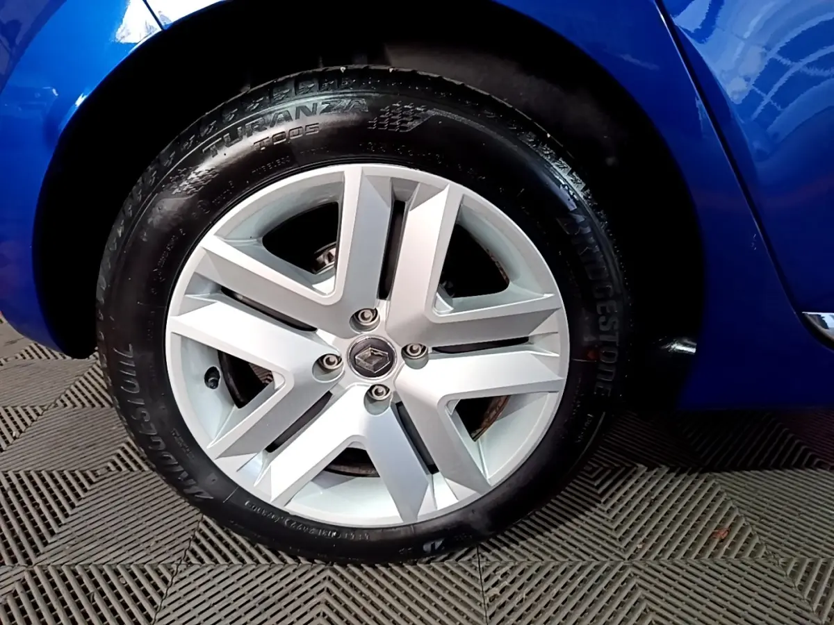 Gros plan sur la roue avant gauche d’une Renault Clio Business bleu, avec jante alliage et pneu Bridgestone.