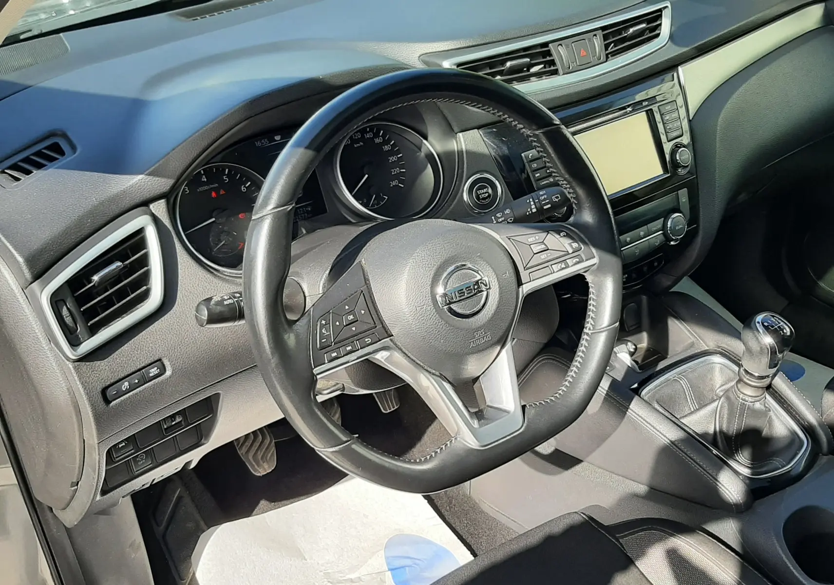 Vue intérieure du tableau de bord du Nissan Qashqai 1.2 DIG-T 115CH N-Connecta 2018, volant cuir et boîte manuelle.
