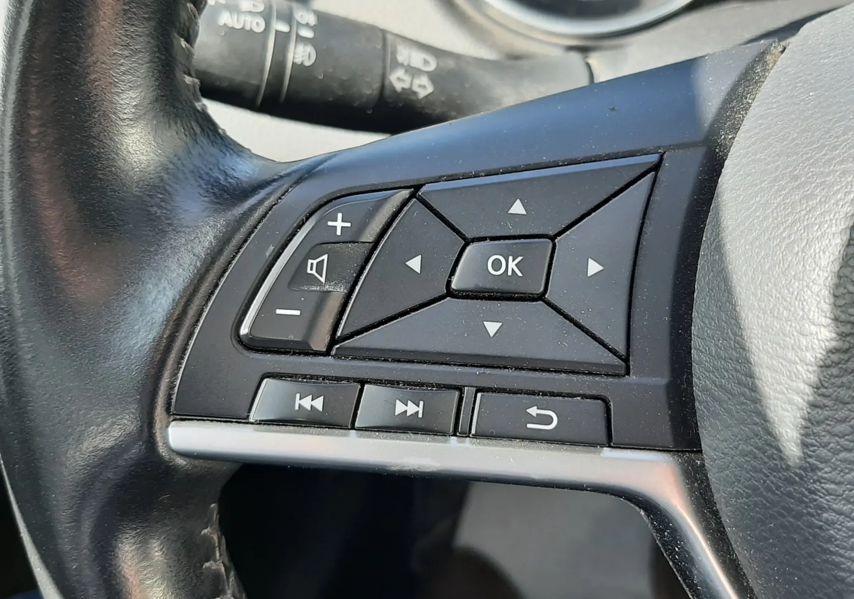Gros plan sur les commandes noires au volant cuir noir du Nissan Qashqai 1.2 DIG-T 115CH N-Connecta de 2018.