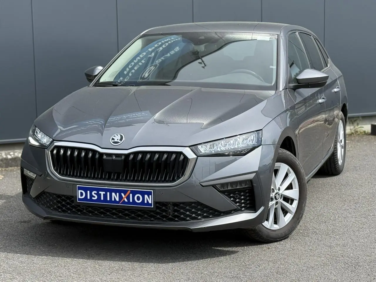 Vue 3/4 avant d'une Skoda Scala TSI 116 gris graphite avec calandre noire et jantes alliage 16 pouces.