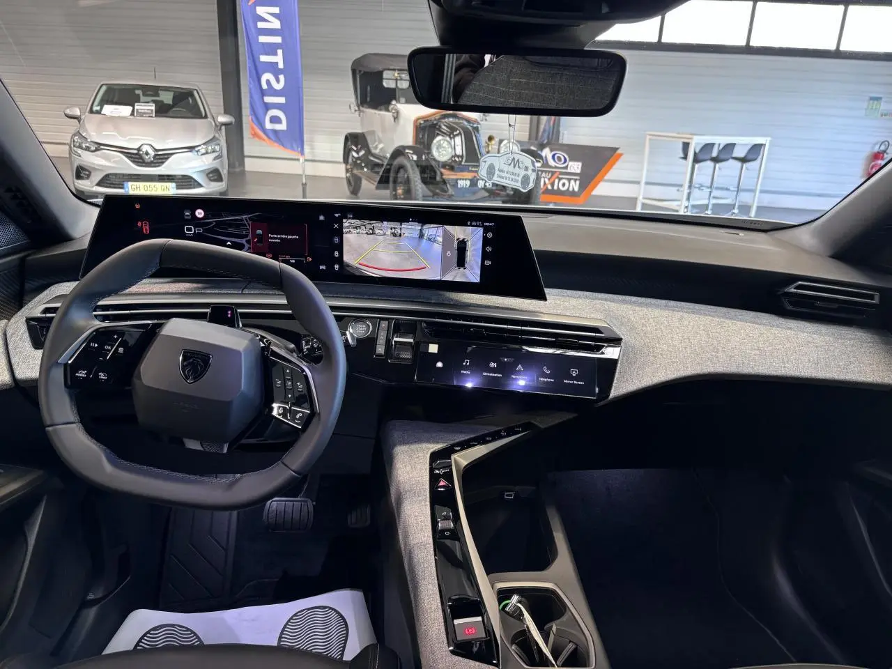 Intérieur du Peugeot 3008 hybride 2026, vue du poste de conduite avec volant compact et écran incurvé panoramique.