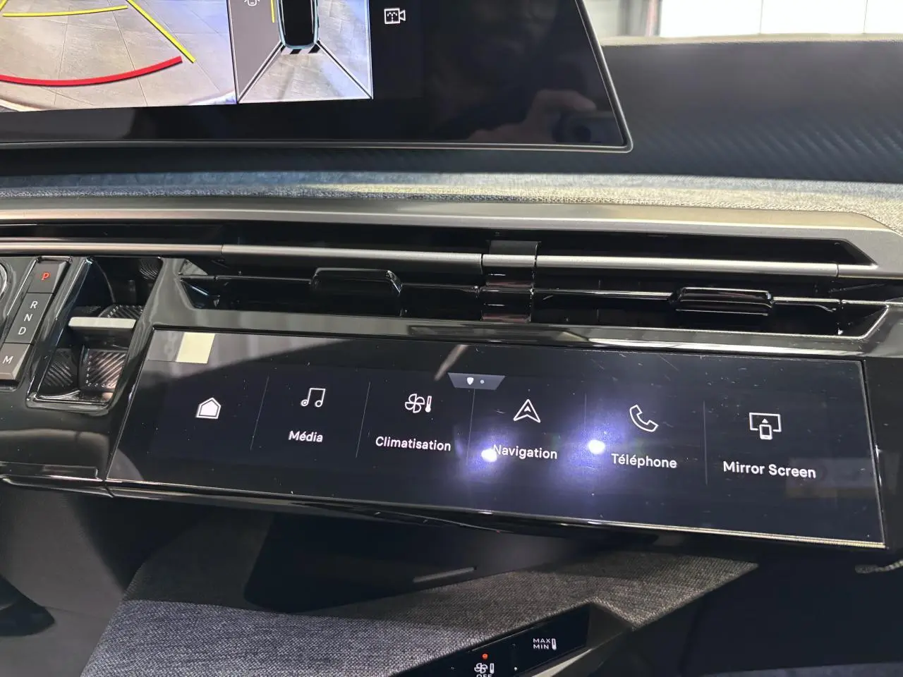 Vue rapprochée de la console centrale tactile noire du Peugeot 3008 blanc, affichant les commandes multimédia et climatisation.
