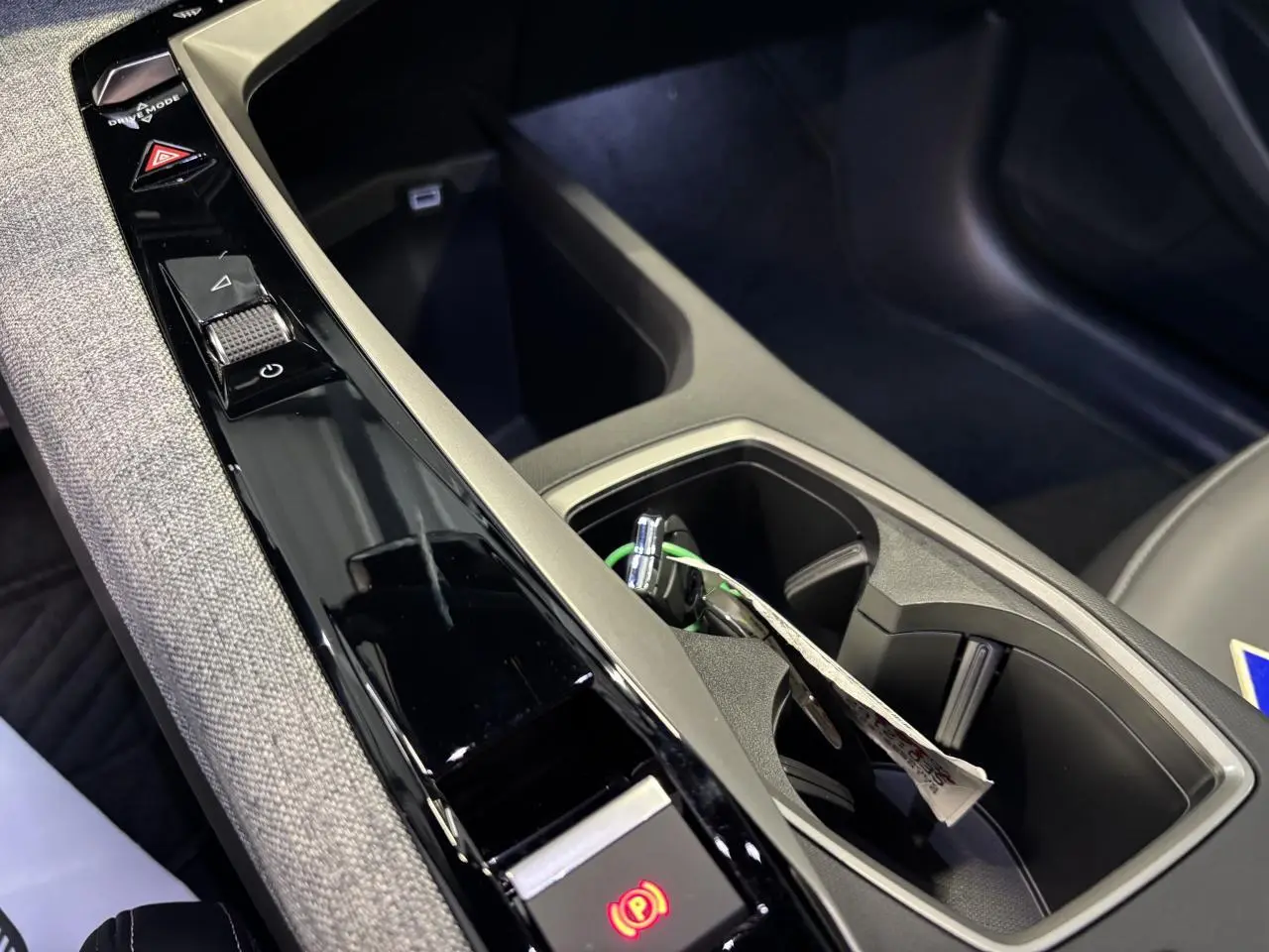Détail de la console centrale noire et grise avec commande frein à main électrique du Peugeot 3008 hybride blanc.