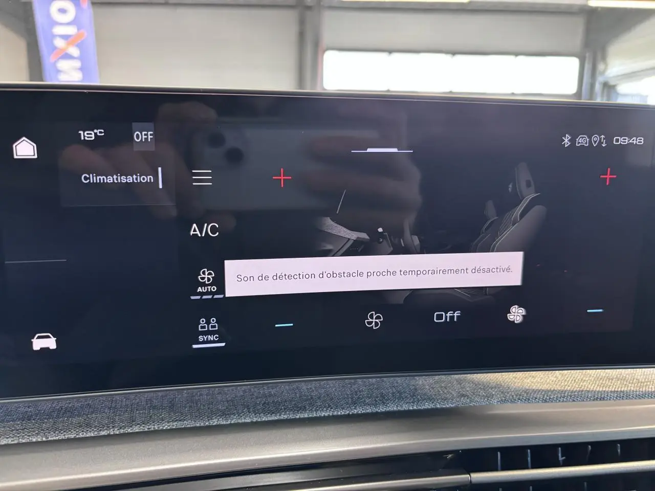 Écran tactile central du Peugeot 3008 blanc, affichant le menu climatisation avec message de détection d'obstacle désactivée.