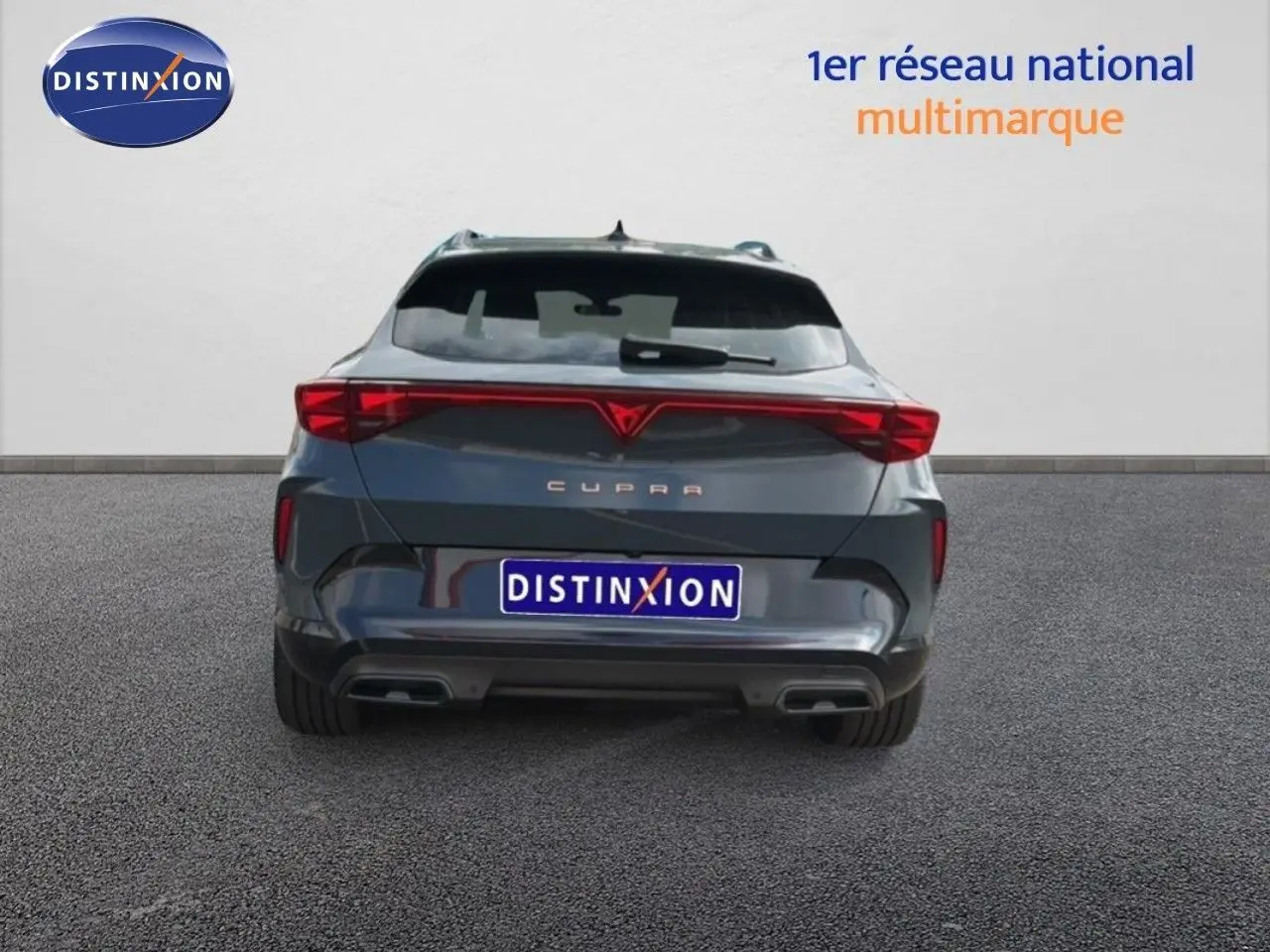Vue arrière d'un CUPRA Formentor gris magnétique métal avec feux LED reliés et double sortie d'échappement.
