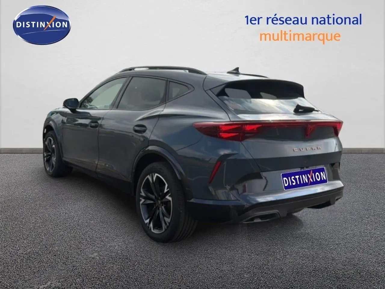 Vue 3/4 arrière droite d’un CUPRA Formentor gris magnétique métal avec jantes noires et feux arrière LED.