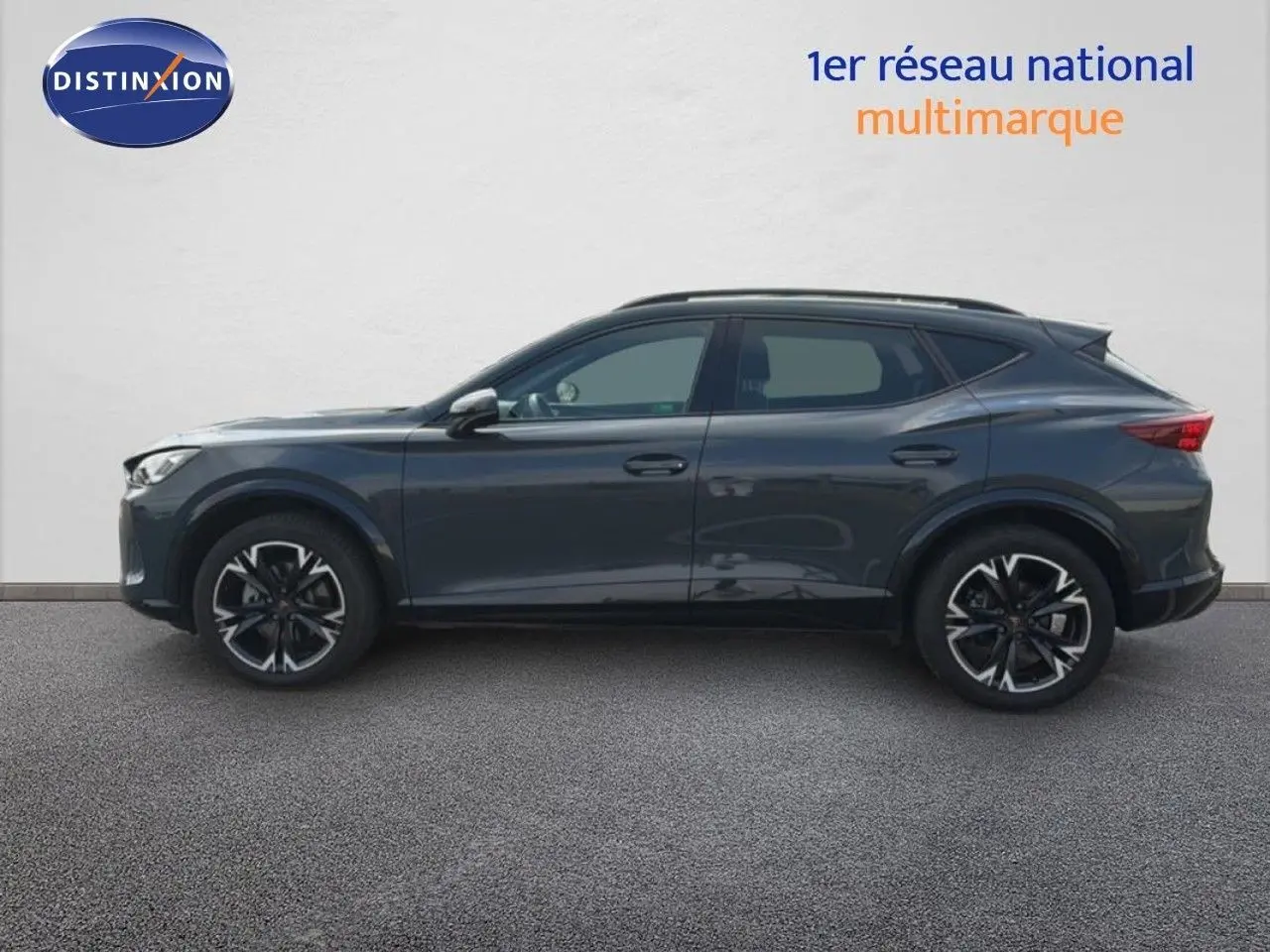 Vue de profil côté gauche d'un CUPRA Formentor gris magnétique métal avec jantes noires et détails sportifs.