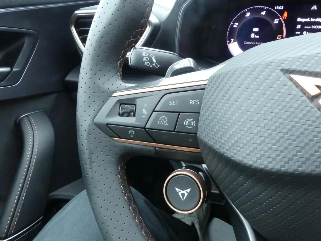 Gros plan sur le volant perforé noir avec surpiqûres cuivrées et commandes multifonctions du CUPRA Formentor 2025.