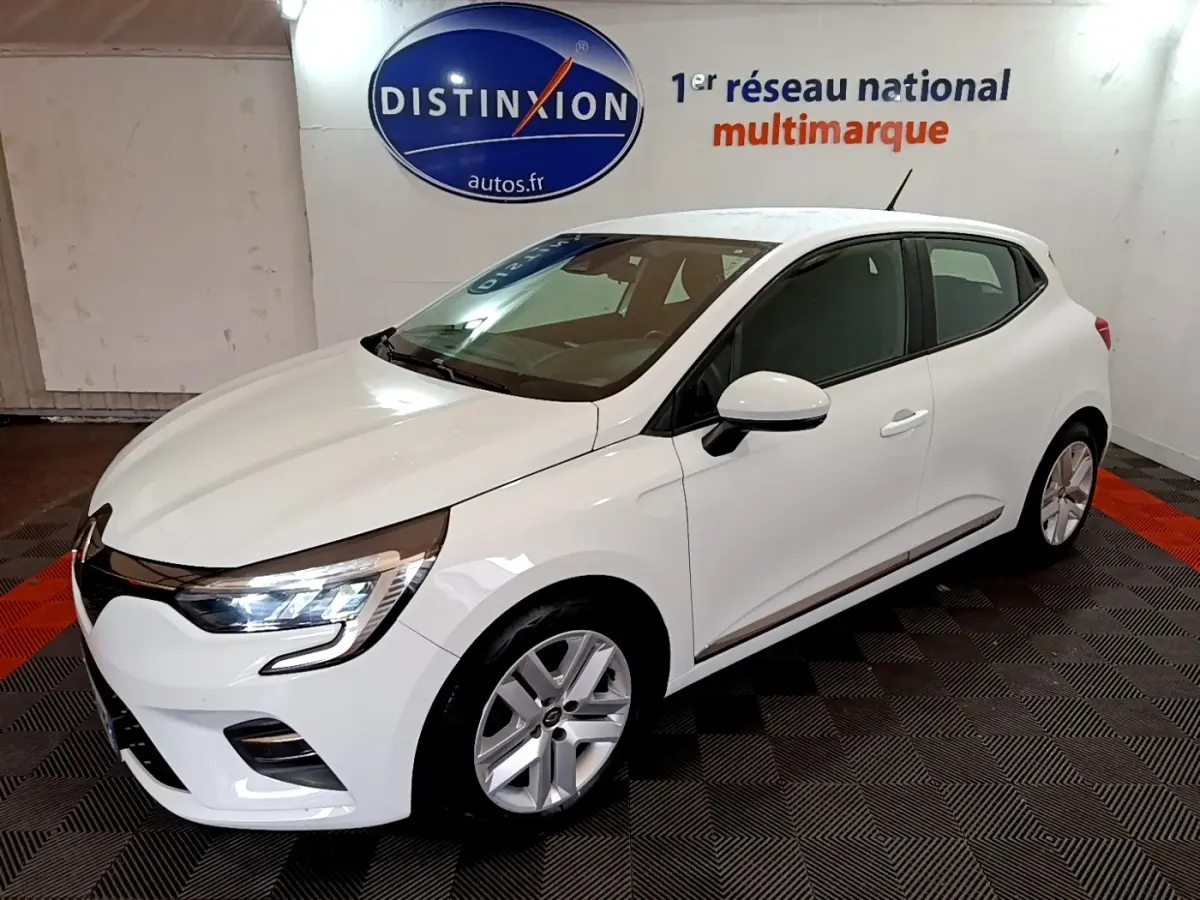 Renault Clio Business TCe 100 blanche vue 3/4 avant droit, avec phares LED allumés dans un showroom.