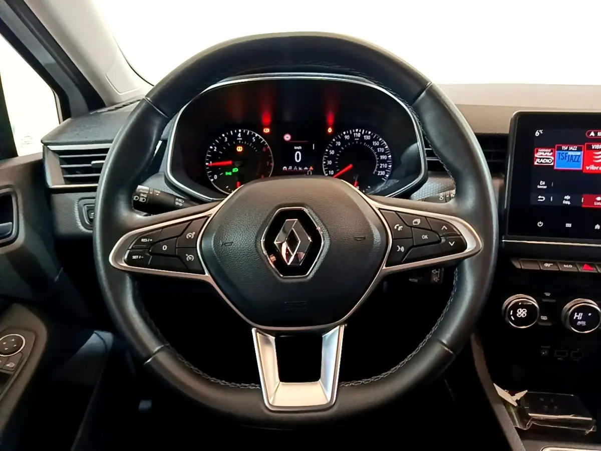 Vue rapprochée du volant en cuir synthétique noir de la Renault Clio Business TCe 100, avec tableau de bord et écran tactile.