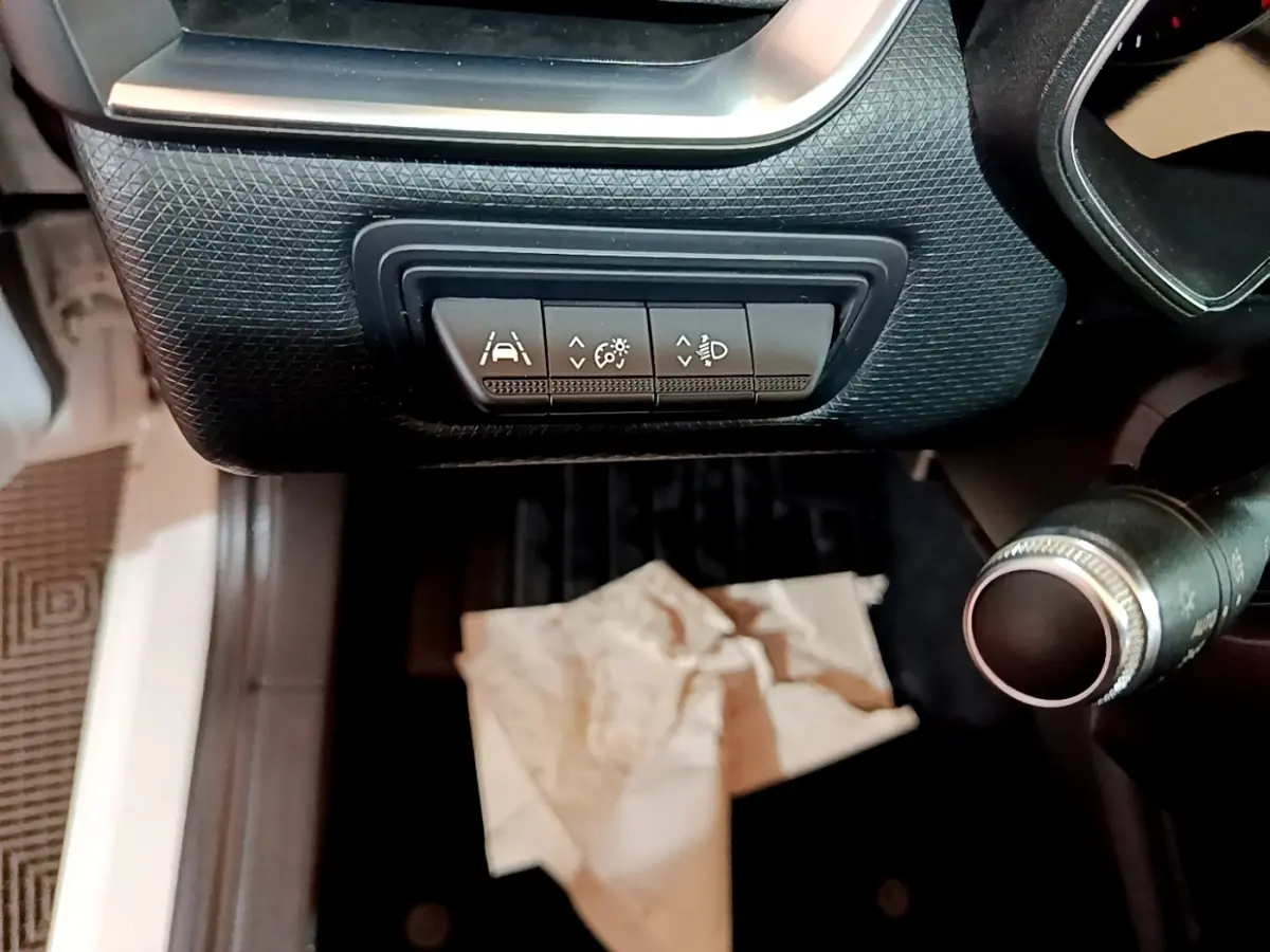 Vue intérieure du tableau de bord côté gauche de la Renault Clio blanche, avec commandes d’assistance à la conduite visibles.