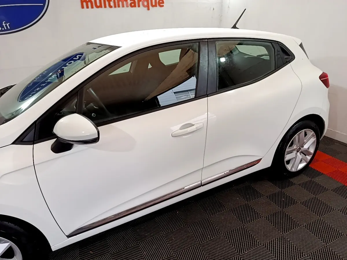 Profil côté gauche d'une Renault Clio Business TCe 100 blanche de 2020, avec jantes alliage et rétroviseur blanc.