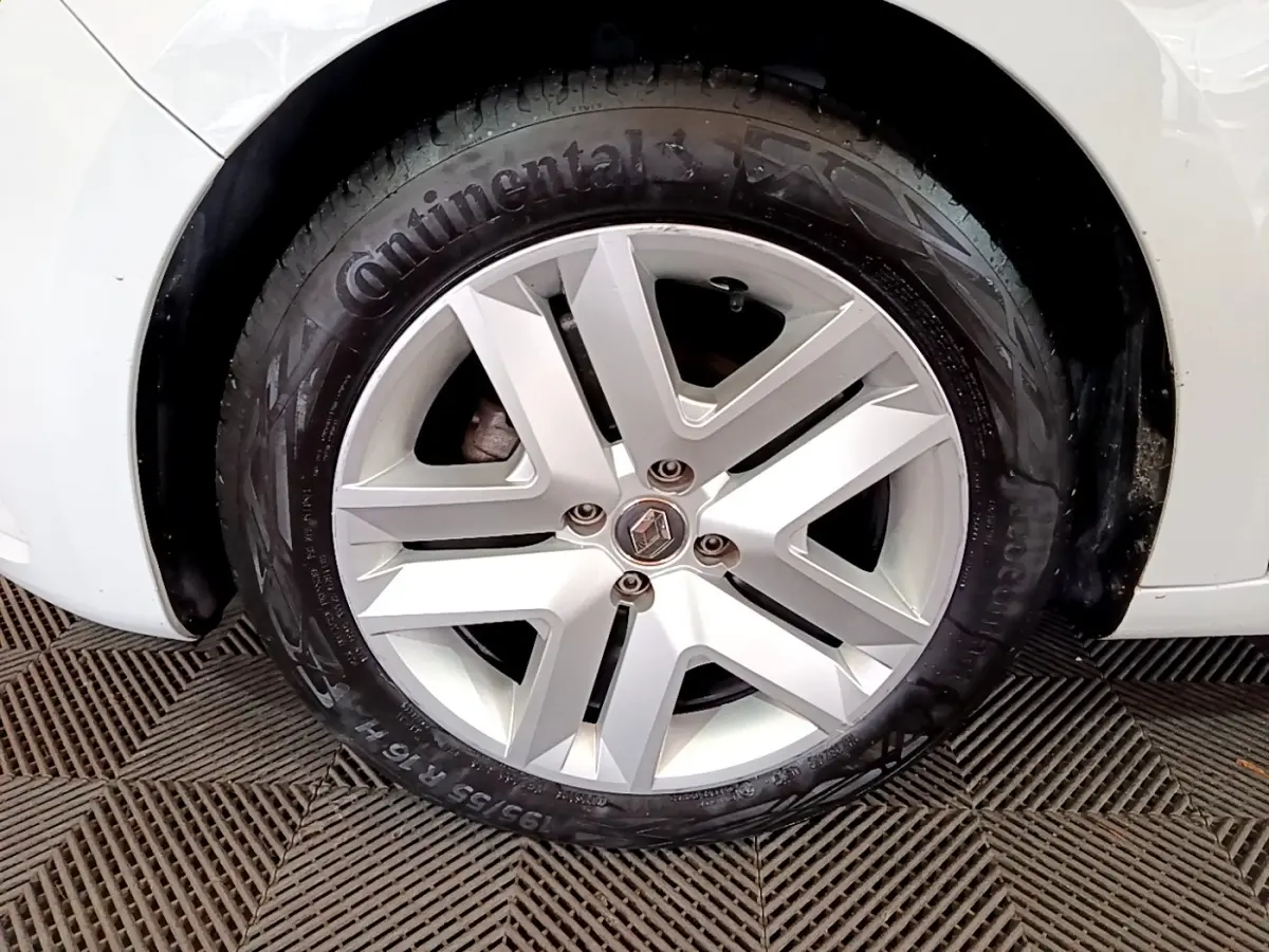 Gros plan sur la roue avant droite blanche d'une Renault Clio Business TCe 100 avec jante alliage et pneu Continental.