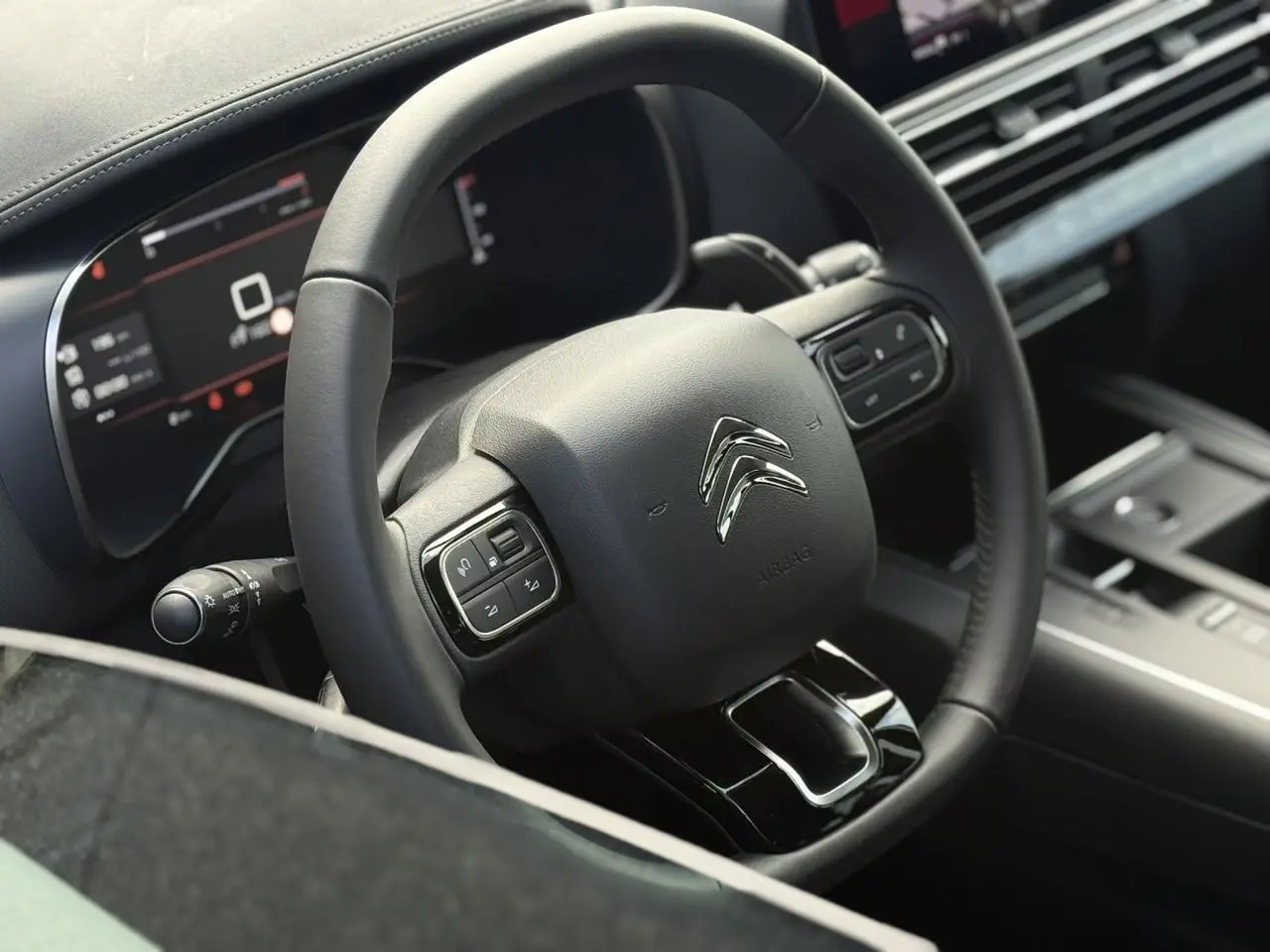 Vue rapprochée du volant cuir noir du Citroën C5 Aircross 2026 avec commandes intégrées et tableau de bord numérique.