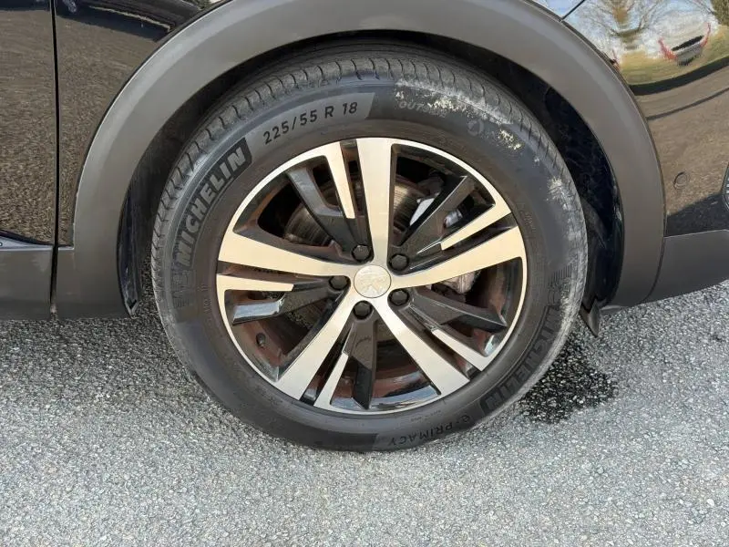 Gros plan sur la roue avant gauche du Peugeot 3008 2024 Bleu Célèbes avec jante alliage et pneu Michelin.