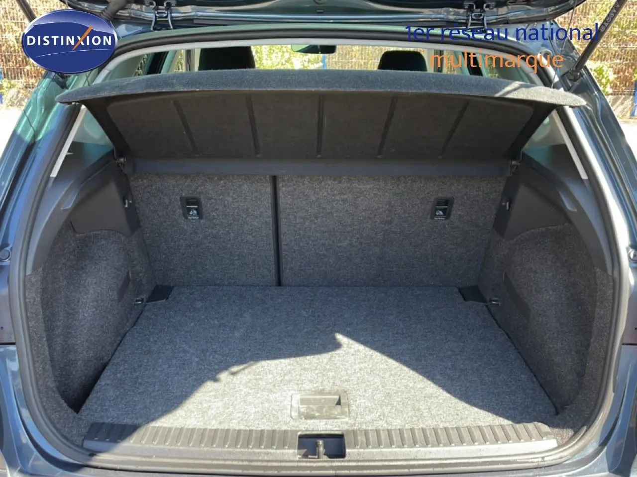 Coffre ouvert vu de l'arrière d'un SEAT Arona gris magnetic metal avec toit noir, montrant l'espace de chargement vide.