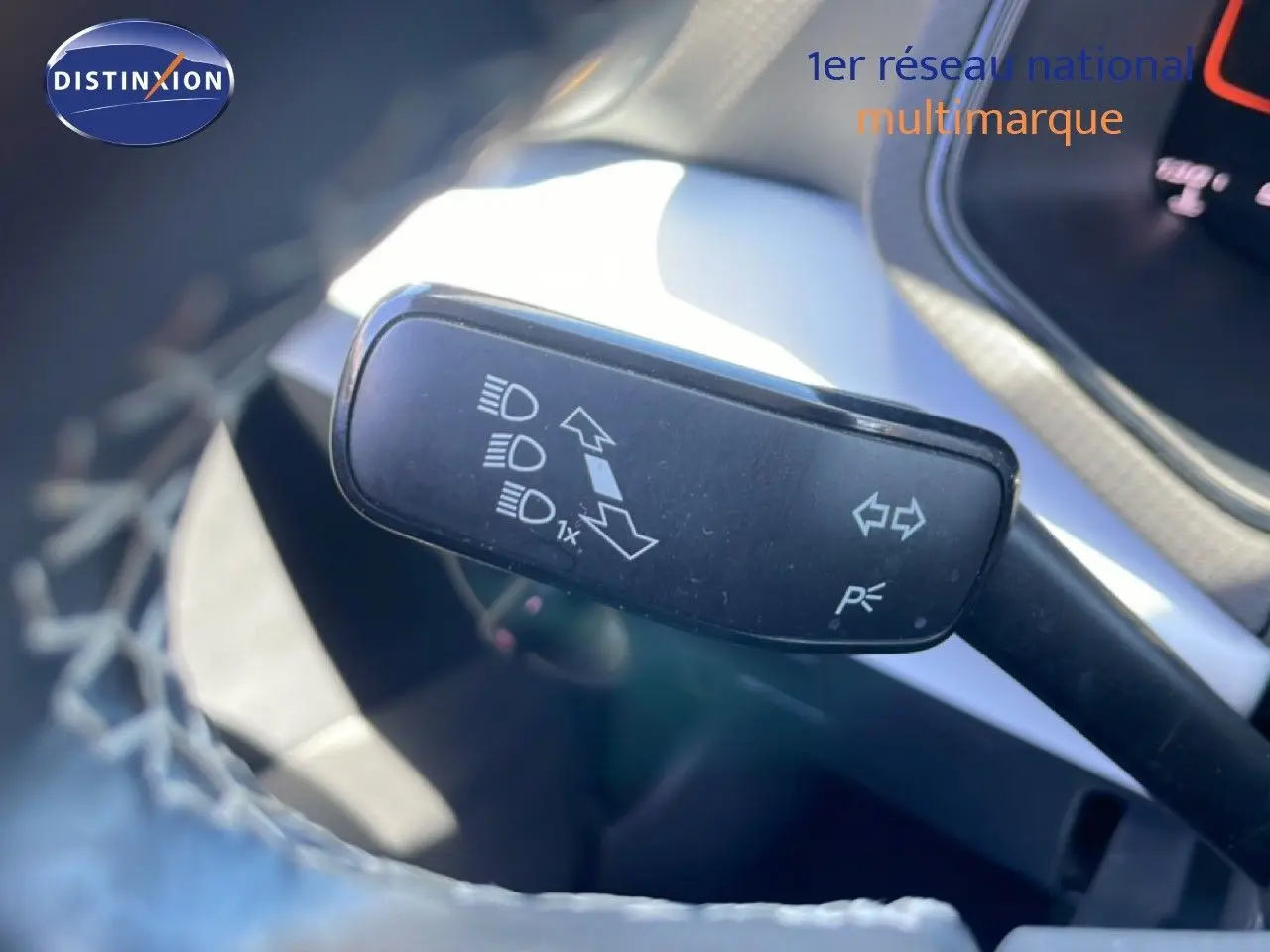 Gros plan sur la commande de clignotants et feux du SEAT Arona 2025, intérieur gris et noir partiellement visible.
