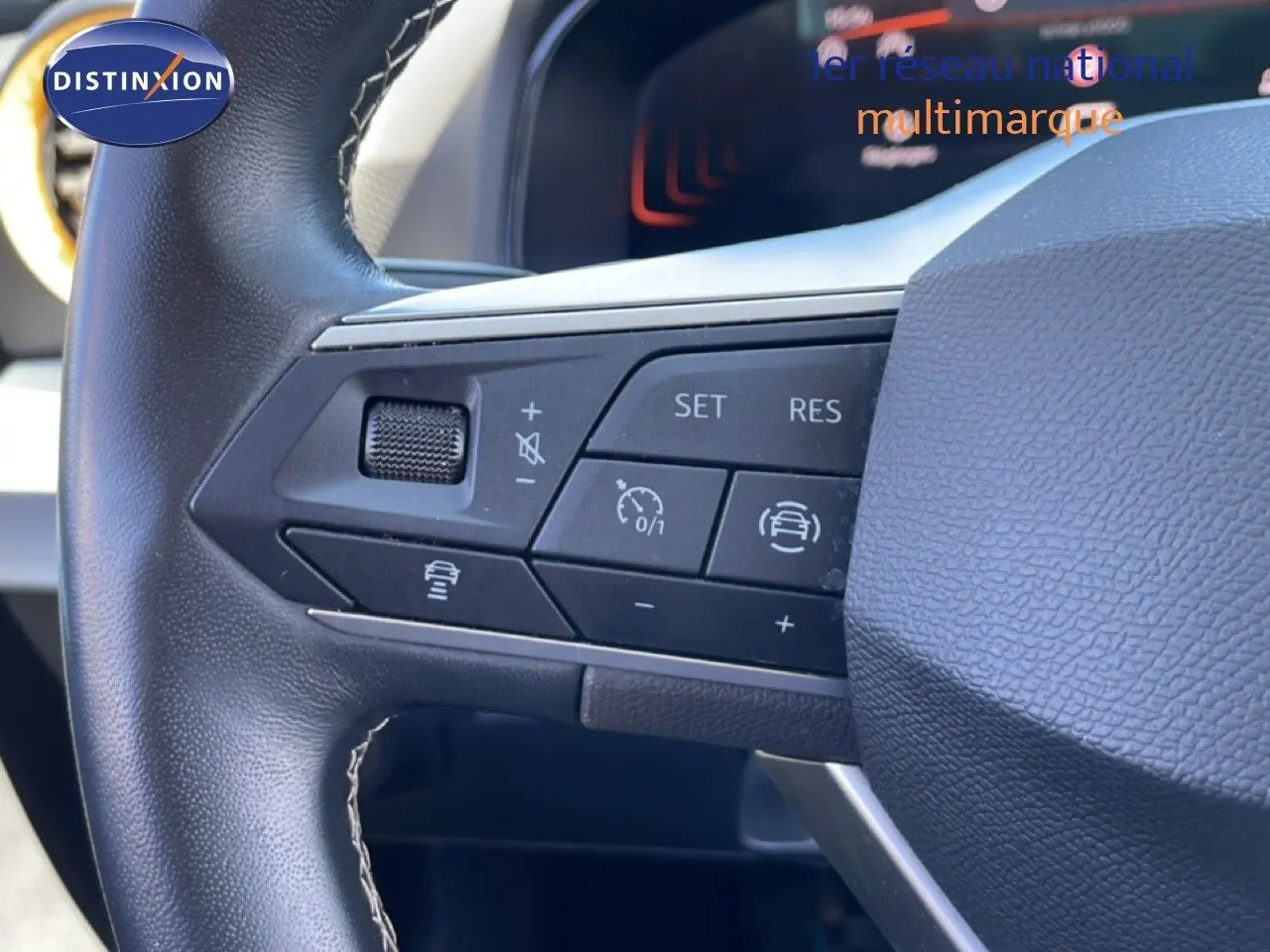 Gros plan sur les commandes au volant en cuir noir du SEAT Arona 2025, mettant en valeur les boutons de régulateur de vitesse.