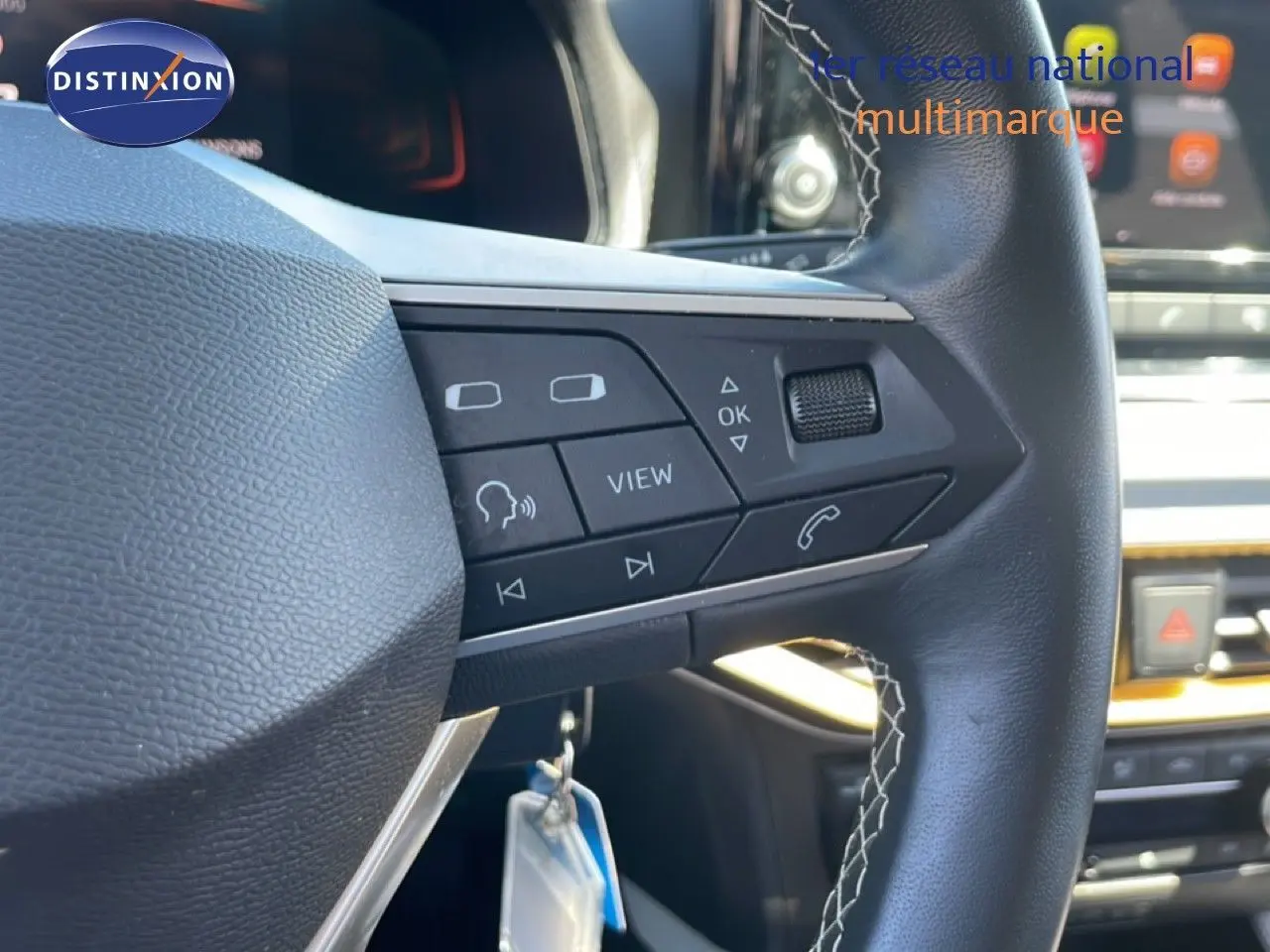 Gros plan sur le volant en cuir noir avec commandes multifonctions du SEAT Arona gris Magnetic Metal, intérieur moderne.