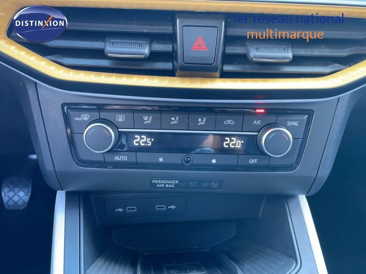 Gros plan sur la console centrale du SEAT Arona 2025, montrant la climatisation digitale et les commandes en noir avec contour jaune.
